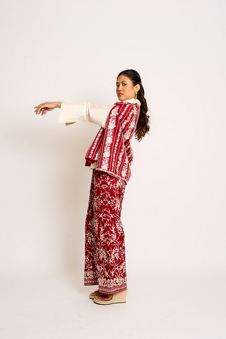A model showcasing Cherry Red Giro Cape And Pants Set by Ashtar from Ashtar's collection