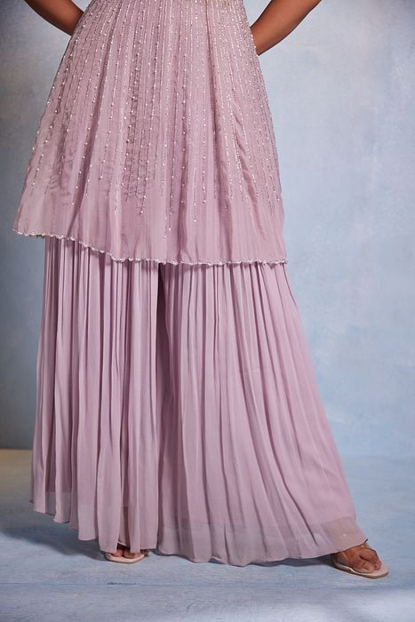 A model showcasing Itisha Peplum And Sharara Set by Muditaa By Urmila from Muditaa By Urmila's collection