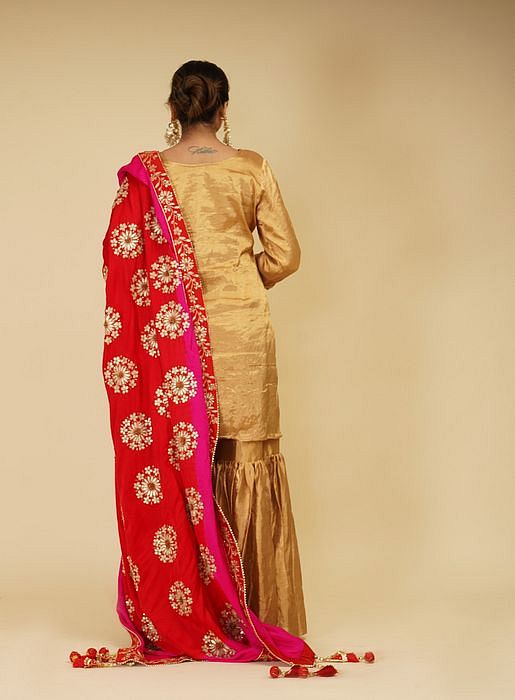 A model showcasing Golden Sharara Set With Pink Red Dupatta by Farha Syed from Farha Syed's collection