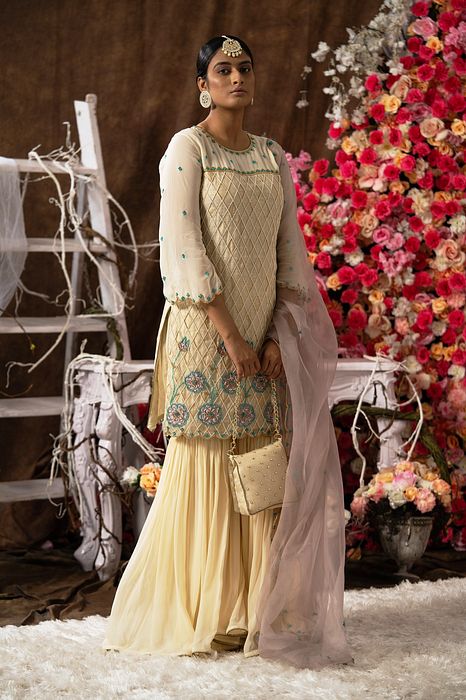 A model showcasing Ivory Garara Set With Handbag by Farha Syed from Farha Syed's collection