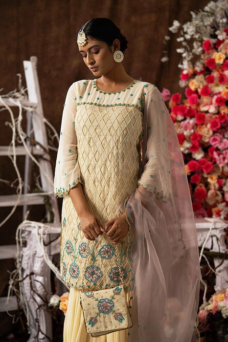 A model showcasing Ivory Garara Set With Handbag by Farha Syed from Farha Syed's collection