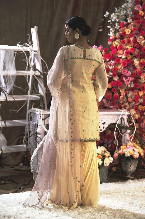 A model showcasing Ivory Garara Set With Handbag by Farha Syed from Farha Syed's collection