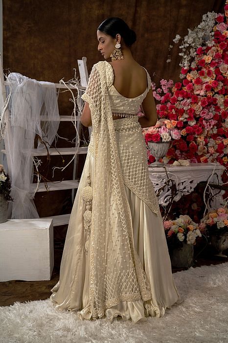 A model showcasing Ivory Lehenga Set With Handbag by Farha Syed from Farha Syed's collection