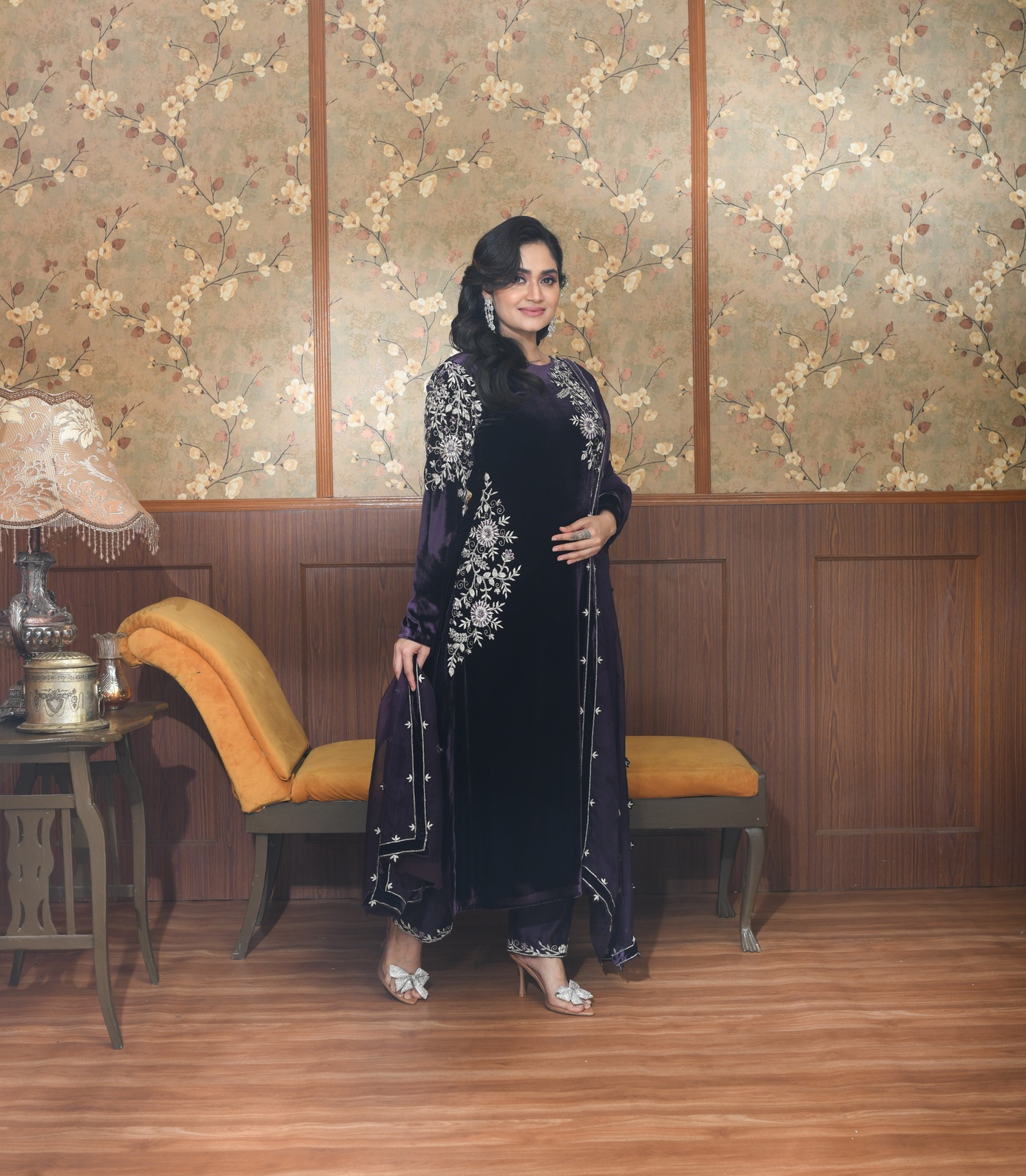 A model showcasing Zia Purple Velvet Suit Set by Ayushi Agarwal from Ayushi Agarwal's collection A model showcasing Zia Purple Velvet Suit Set by Ayushi Agarwal from Ayushi Agarwal's collection