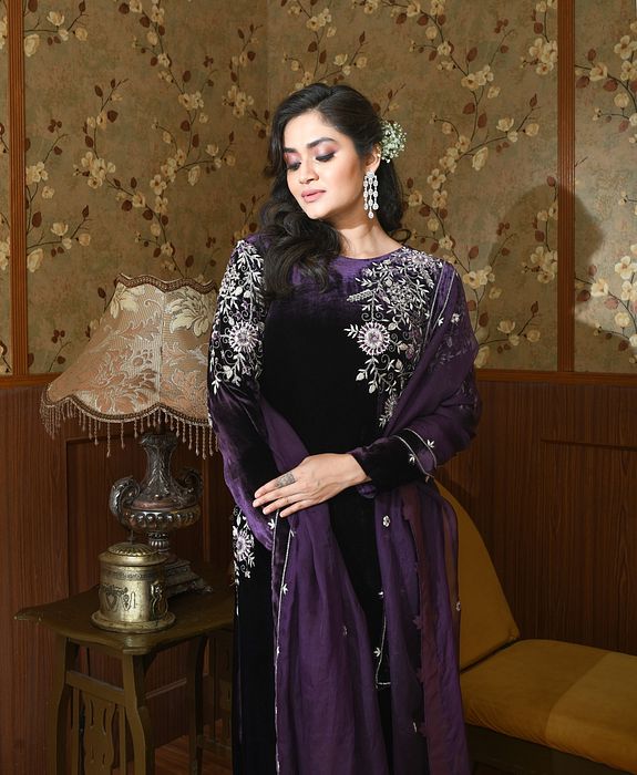 A model showcasing Zia Purple Velvet Suit Set by Ayushi Agarwal from Ayushi Agarwal's collection A model showcasing Zia Purple Velvet Suit Set by Ayushi Agarwal from Ayushi Agarwal's collection