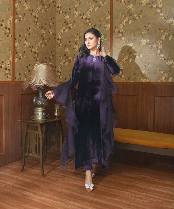 A model showcasing Purple Liora Velvet Suit Set by Ayushi Agarwal from Ayushi Agarwal's collection A model showcasing Purple Liora Velvet Suit Set by Ayushi Agarwal from Ayushi Agarwal's collection