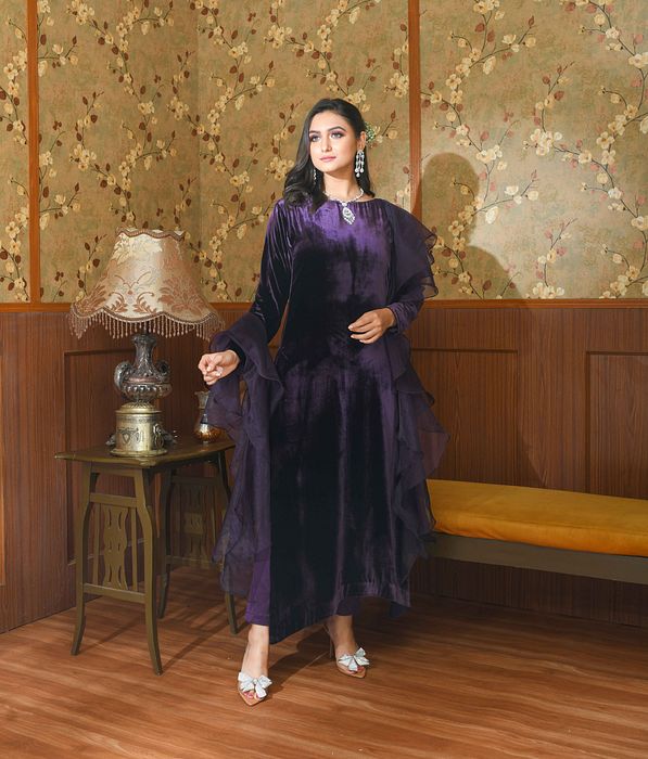 A model showcasing Purple Liora Velvet Suit Set by Ayushi Agarwal from Ayushi Agarwal's collection A model showcasing Purple Liora Velvet Suit Set by Ayushi Agarwal from Ayushi Agarwal's collection