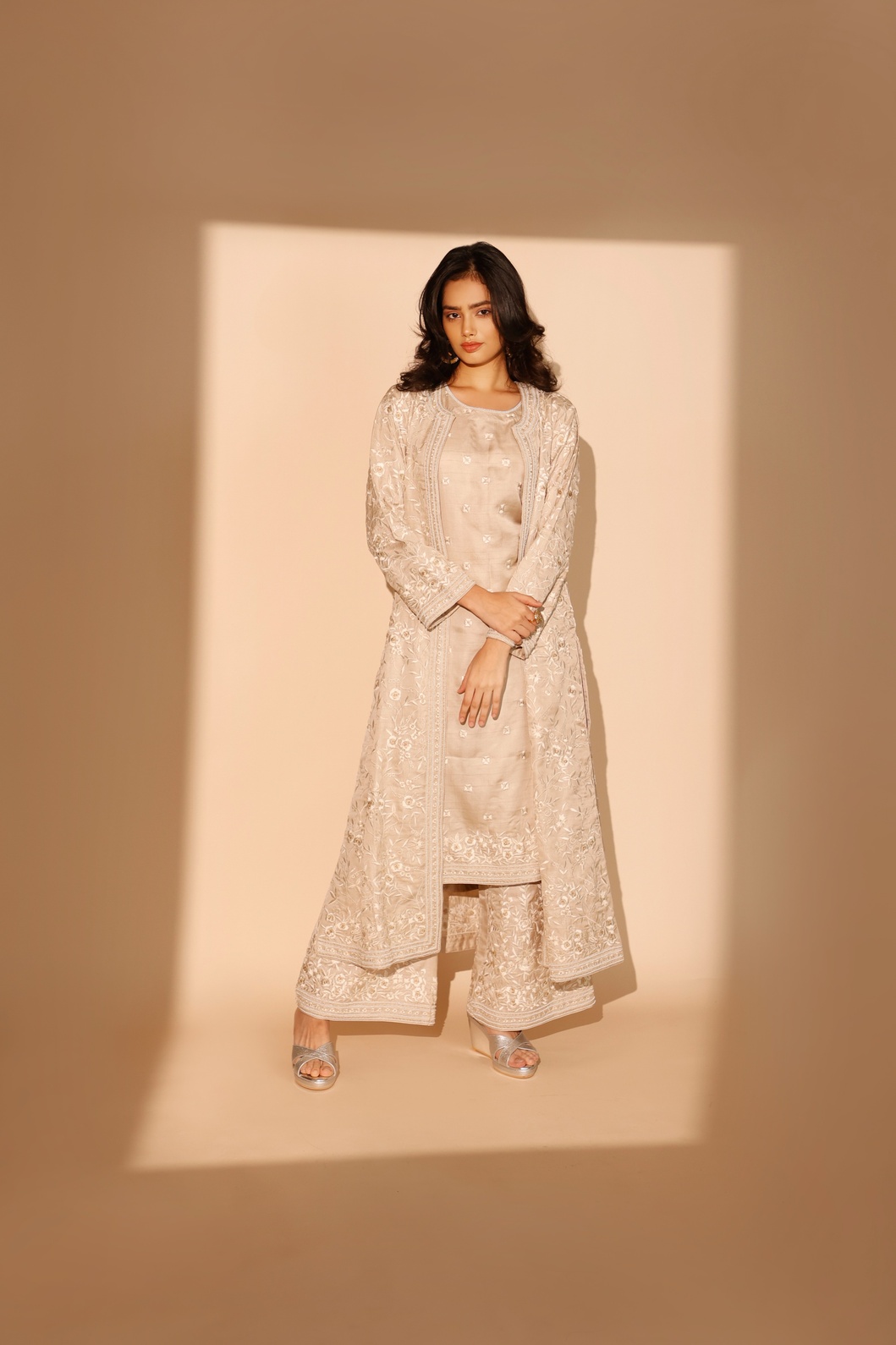 A model showcasing Beige Daffodil Long Jacket Kurta Set by Ashtar from Ashtar's collection