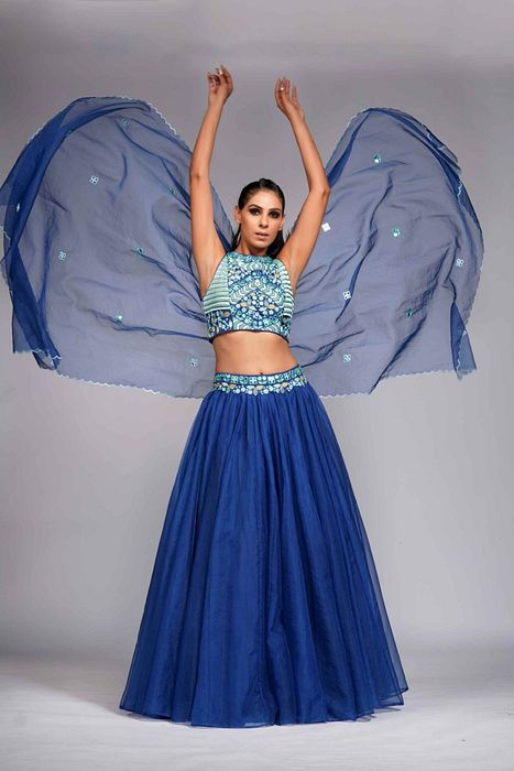 A model showcasing Mirror Work Thread Work Blue Organza Lehenga For Haldi Or Mehandi by Shruti S Label from Shruti S Label's collection