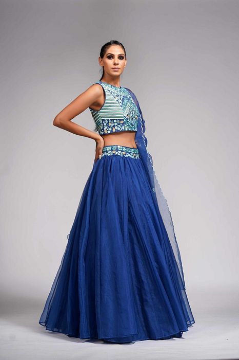 A model showcasing Mirror Work Thread Work Blue Organza Lehenga For Haldi Or Mehandi by Shruti S Label from Shruti S Label's collection