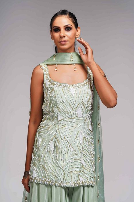 A model showcasing White Pearl Gold Embroidery Sharara Suit In Sea Green by Shruti S Label from Shruti S Label's collection