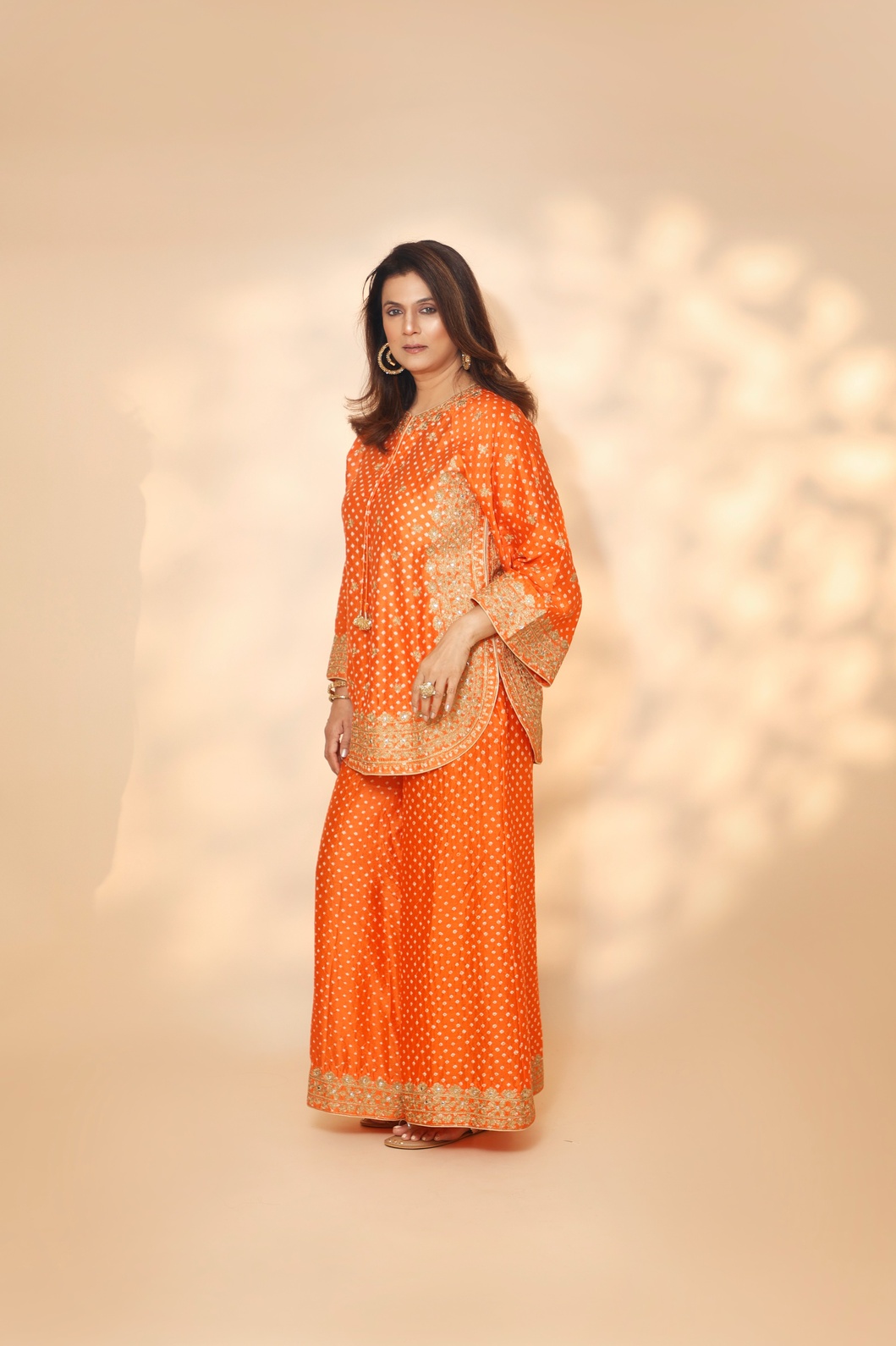 A model showcasing Orange Tarini Sharara Set by Ashtar from Ashtar's collection