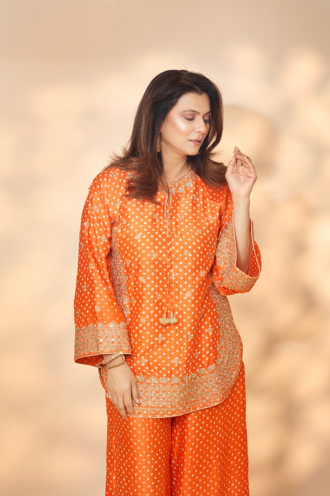 A model showcasing Orange Tarini Sharara Set by Ashtar from Ashtar's collection