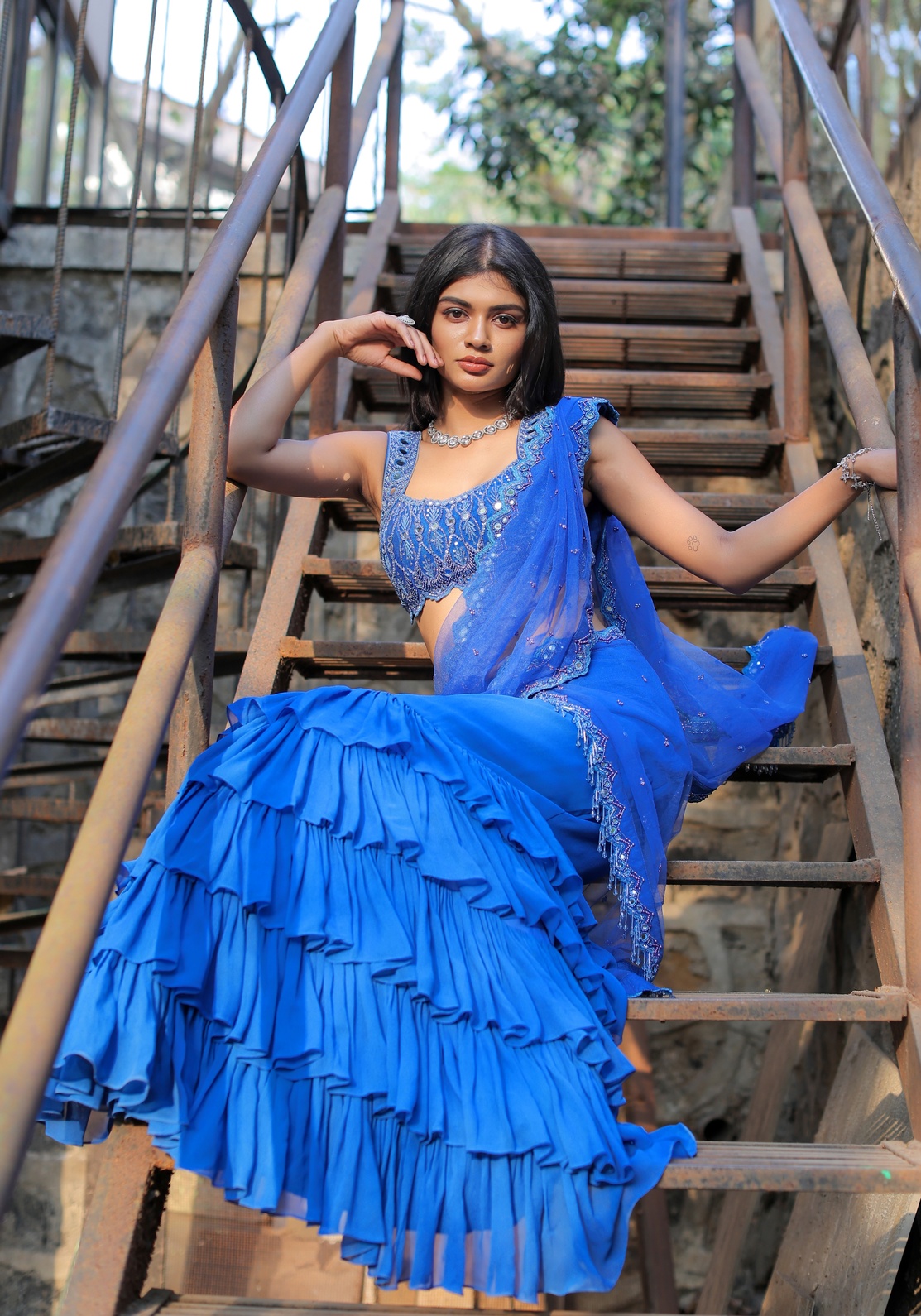 A model showcasing Blue Mirror Embroidered Ruffle Saree Set by Foram Patel from Foram Patel's collection