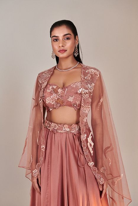 A model showcasing Salmon Pink Cutwork Blouse Applique Lehenga by One Knot One from One Knot One's collection