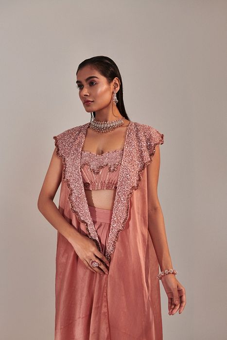 A model showcasing Salmon Pink Cape And Embroidred Blouse by One Knot One from One Knot One's collection