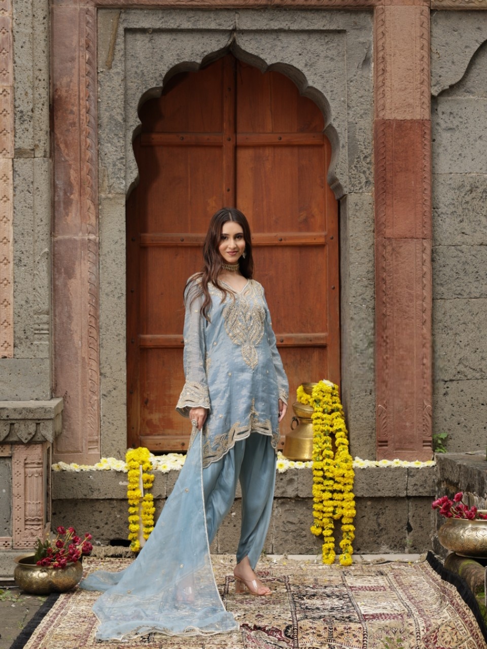 A model showcasing Blue Hand Embroidered Kurta Dhoti Set by Farha Syed from Farha Syed's collection