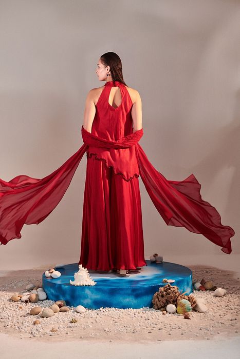 A model showcasing Scarlet Red Cutwork Asymmetric Tunic And Twisted Pleats Dupatta by One Knot One from One Knot One's collection