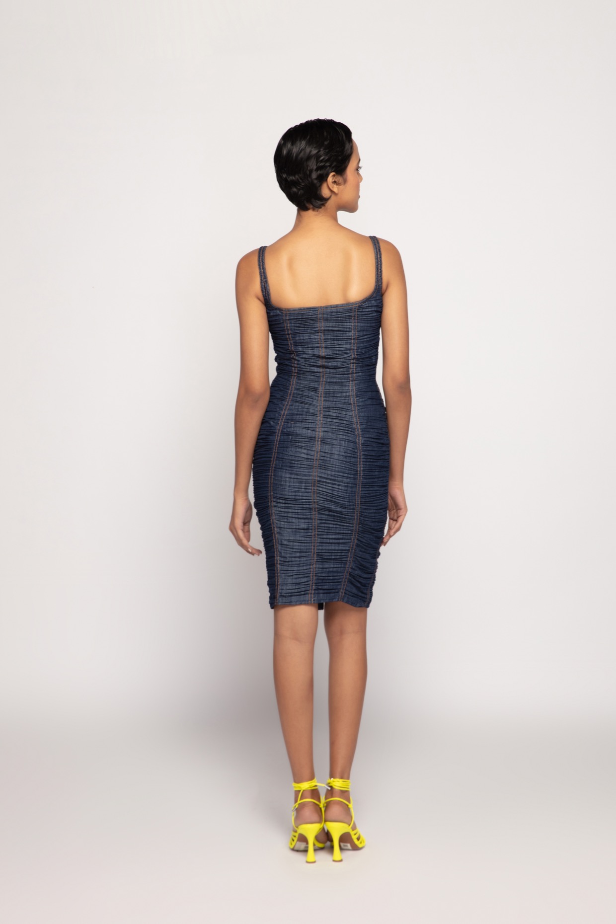 A model showcasing Denim Pleated Mini Dress With Front Zip by Saaksha And Kinni from Saaksha And Kinni's collection