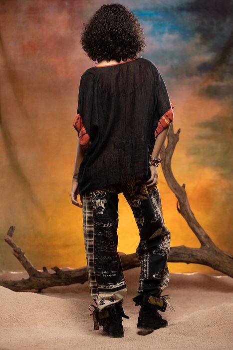 A model showcasing Black Cedar Pants by Capisvirleo from Capisvirleo's collection
