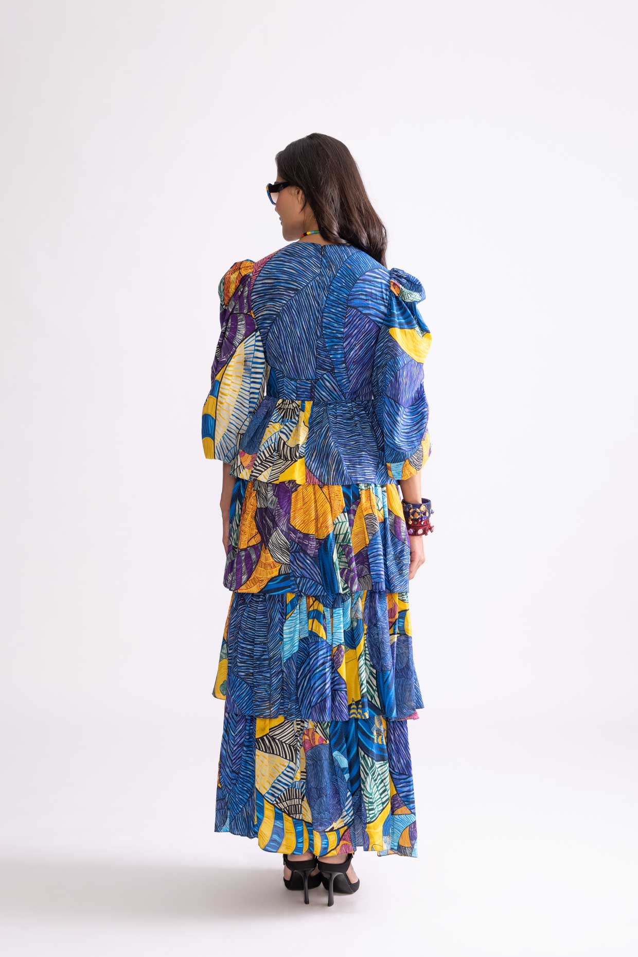 A model showcasing Adalynn Dress Tribal Print Tiered Dress by Saaksha And Kinni from Saaksha And Kinni's collection