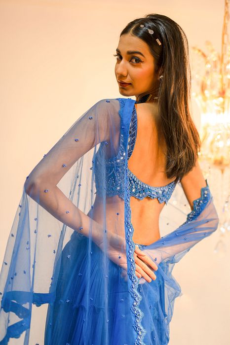 A model showcasing Blue Tiered Mirror Work Lehenga Set by Foram Patel from Foram Patel's collection