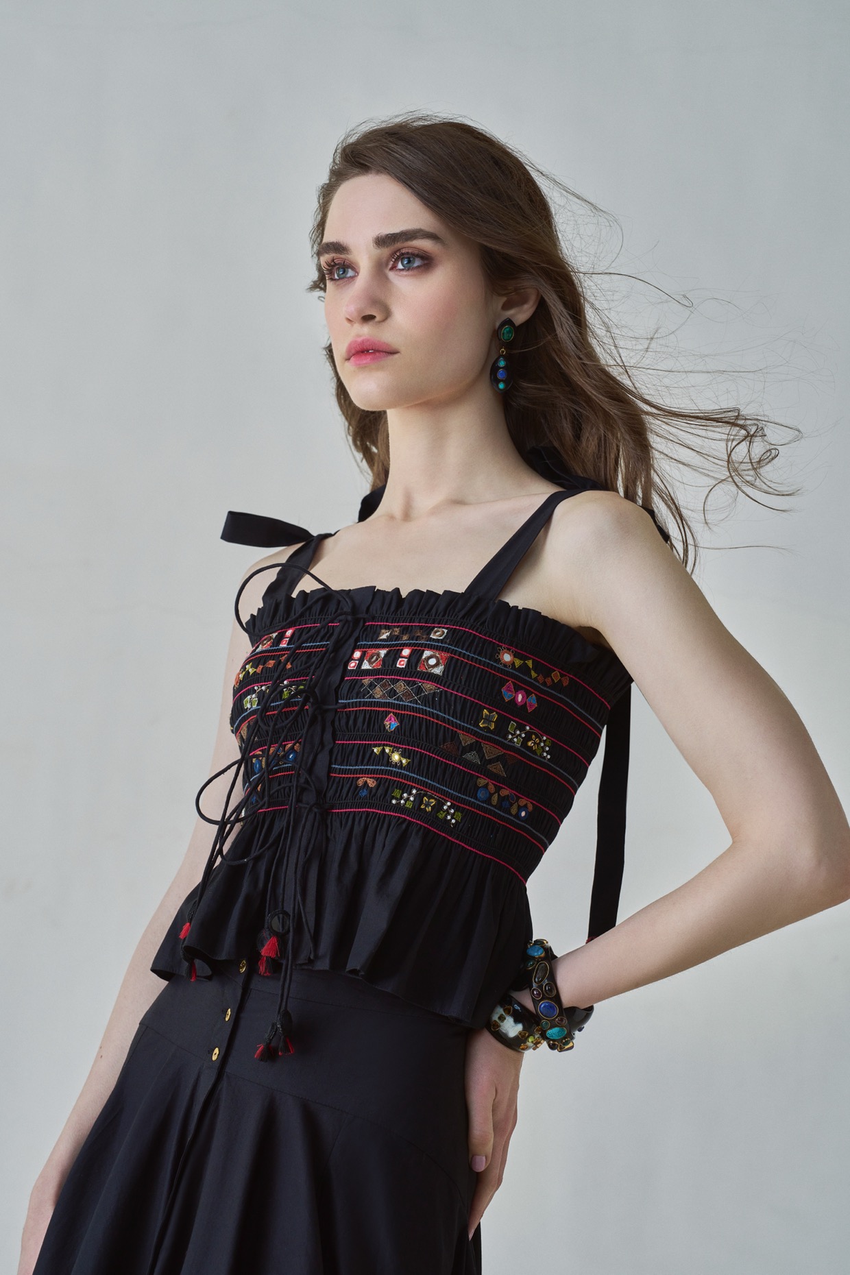 A model showcasing Maya Blouse Black Smocked Peplum Blouse Saaksha Kinni by Saaksha And Kinni from Saaksha And Kinni's collection