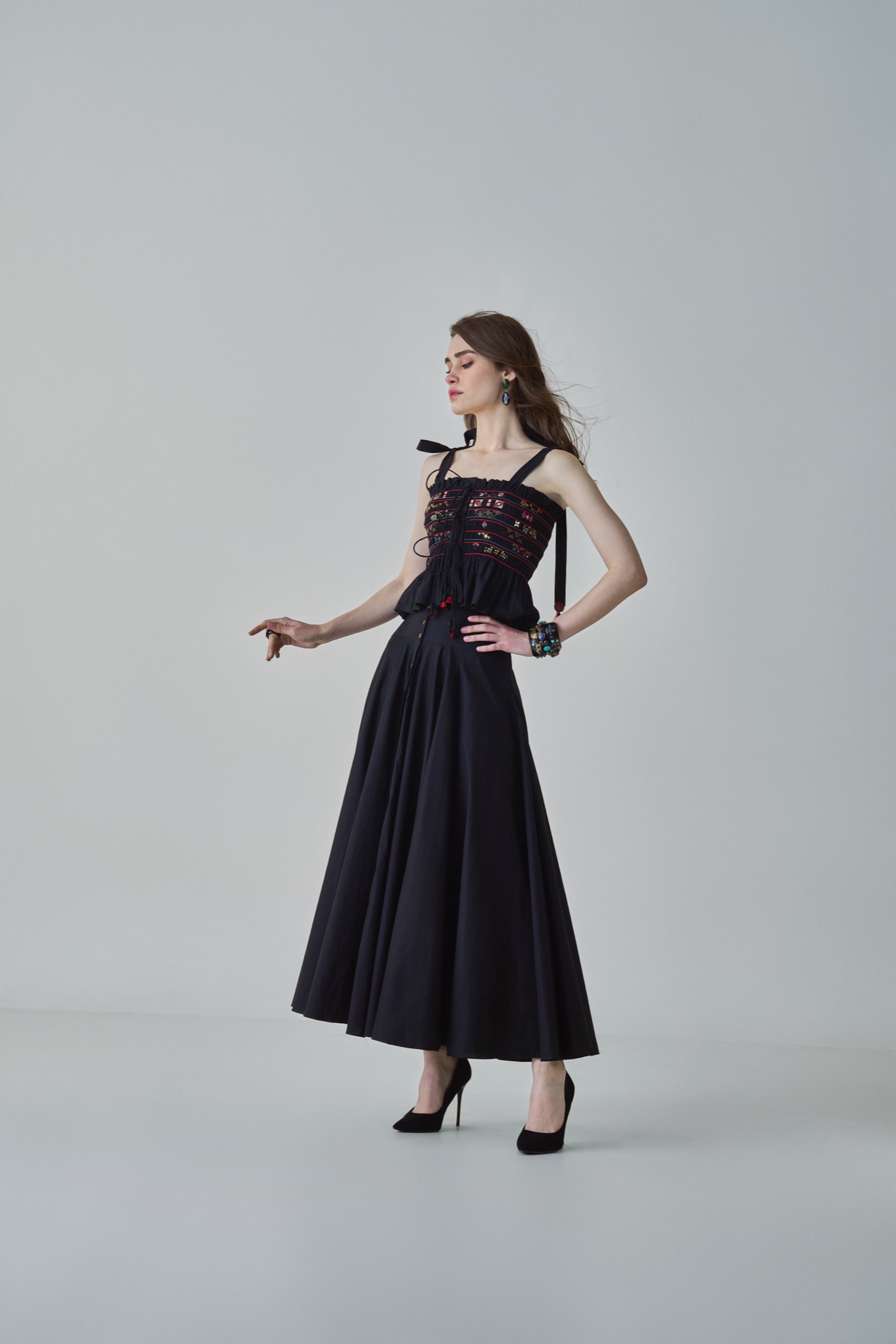 A model showcasing Maya Blouse Black Smocked Peplum Blouse Saaksha Kinni by Saaksha And Kinni from Saaksha And Kinni's collection