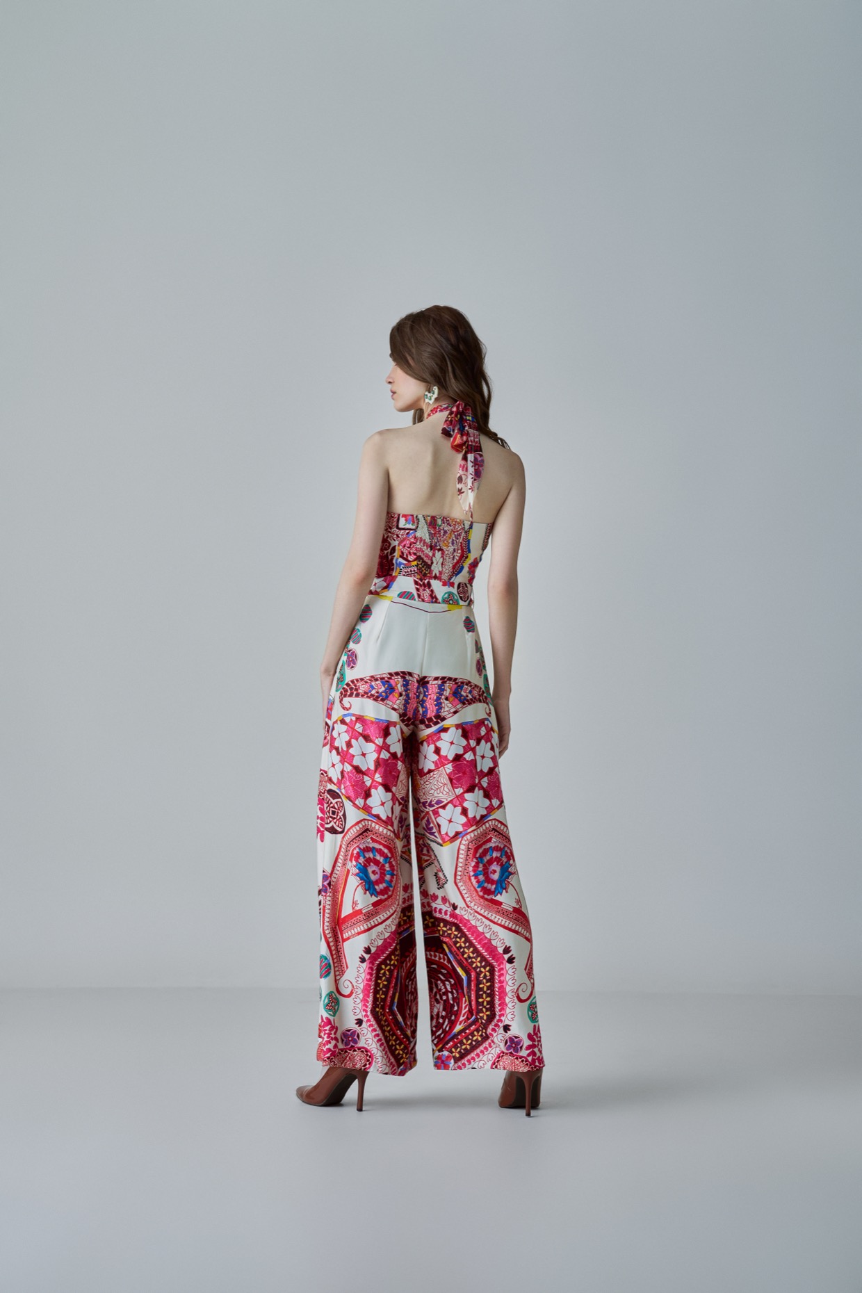 A model showcasing Alexa Jumpsuit Ivory Halter Neck Jumpsuit by Saaksha And Kinni from Saaksha And Kinni's collection