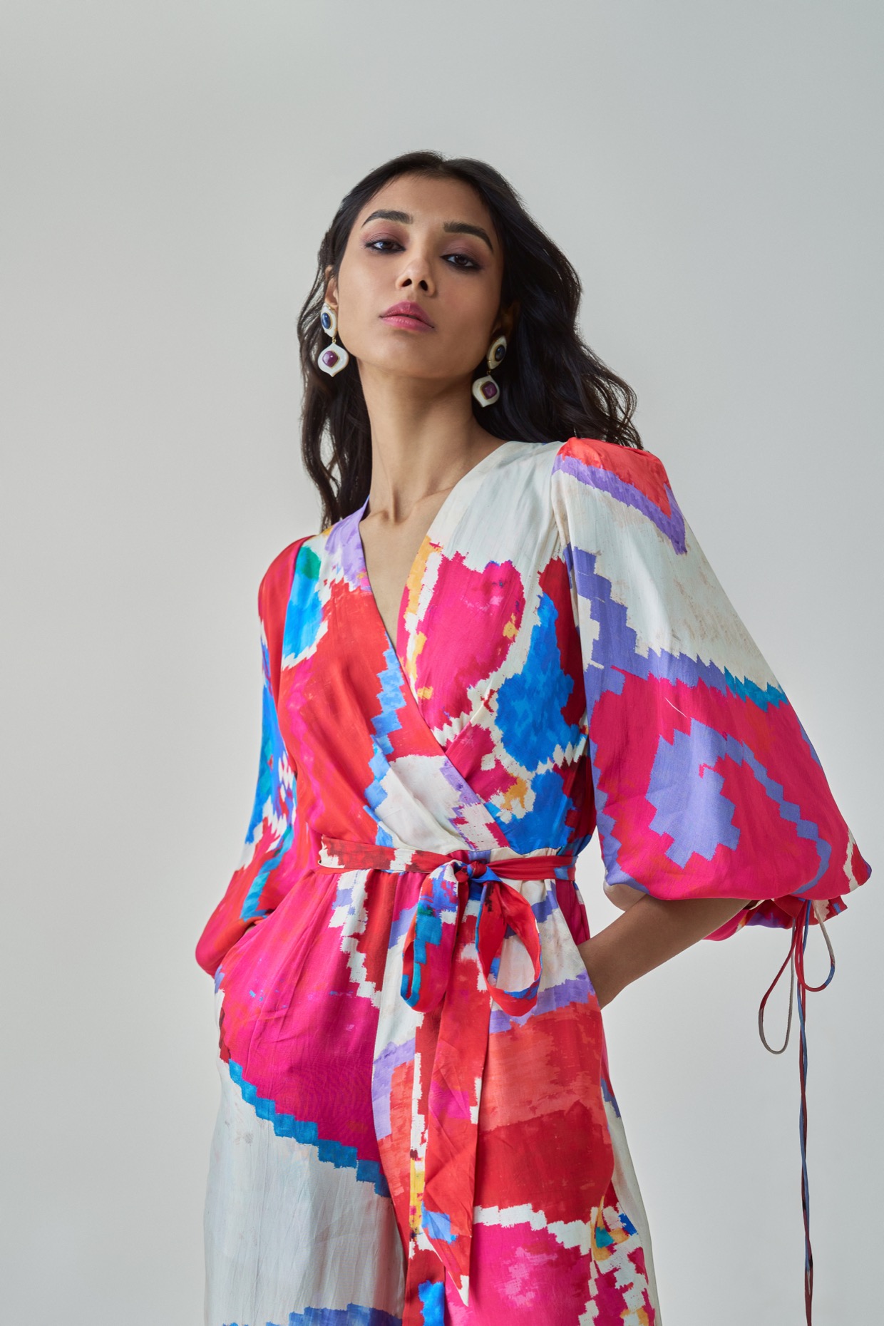 A model showcasing Jenny Jumpsuit Pink Red Overlap Jumpsuit by Saaksha And Kinni from Saaksha And Kinni's collection