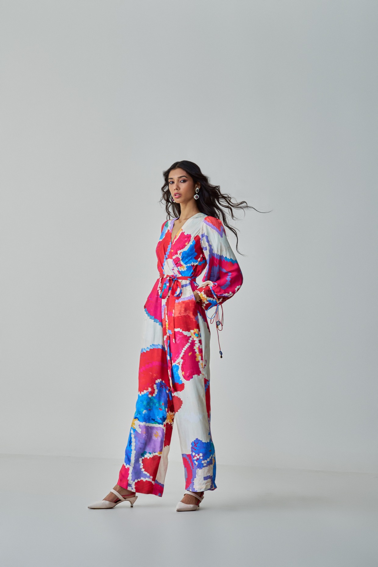 A model showcasing Jenny Jumpsuit Pink Red Overlap Jumpsuit by Saaksha And Kinni from Saaksha And Kinni's collection