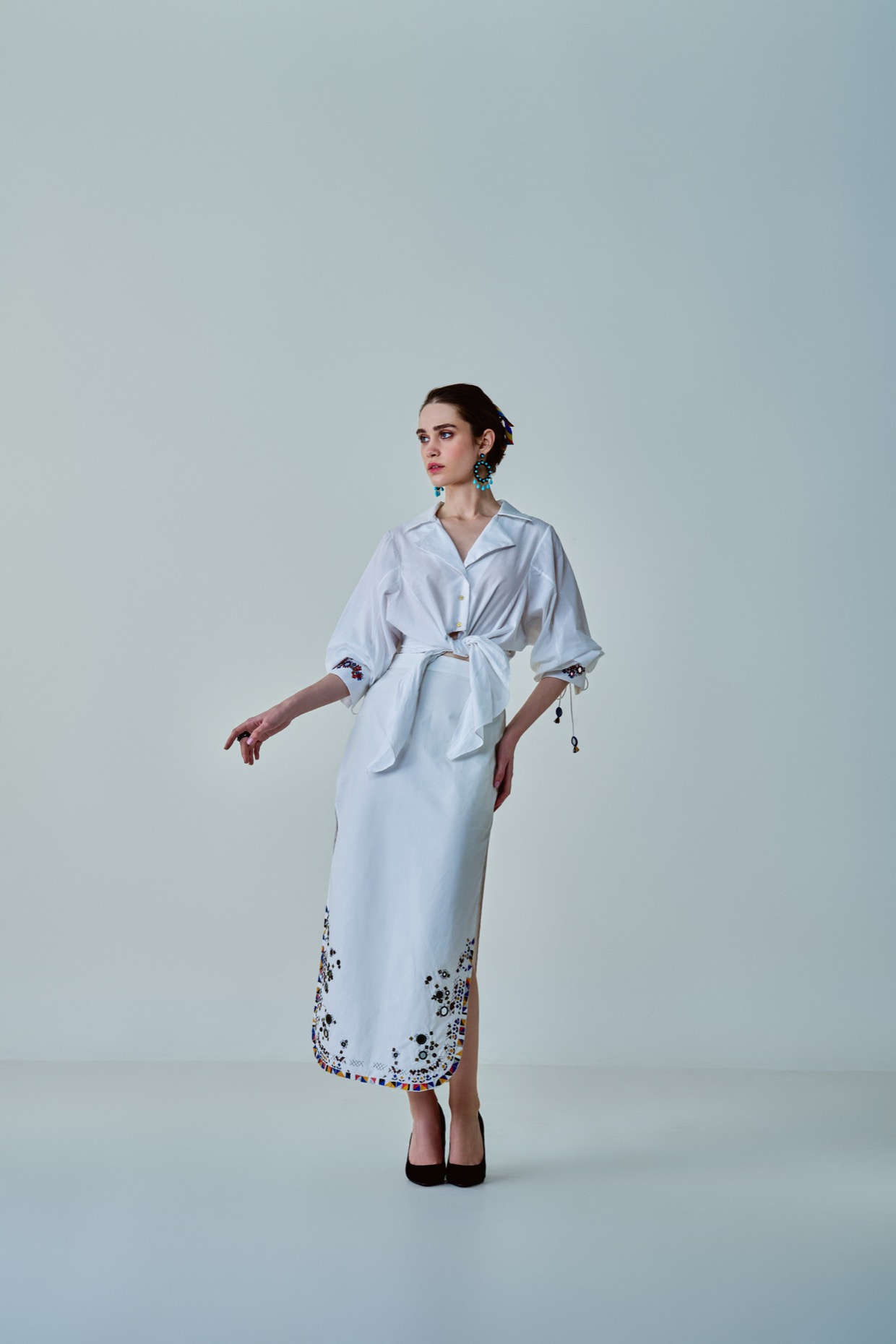 A model showcasing Olivia Shirt White Hand Embroidered Shirt by Saaksha And Kinni from Saaksha And Kinni's collection