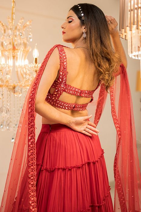 A model showcasing Red Tiered Mirror Work Lehenga Set by Foram Patel from Foram Patel's collection