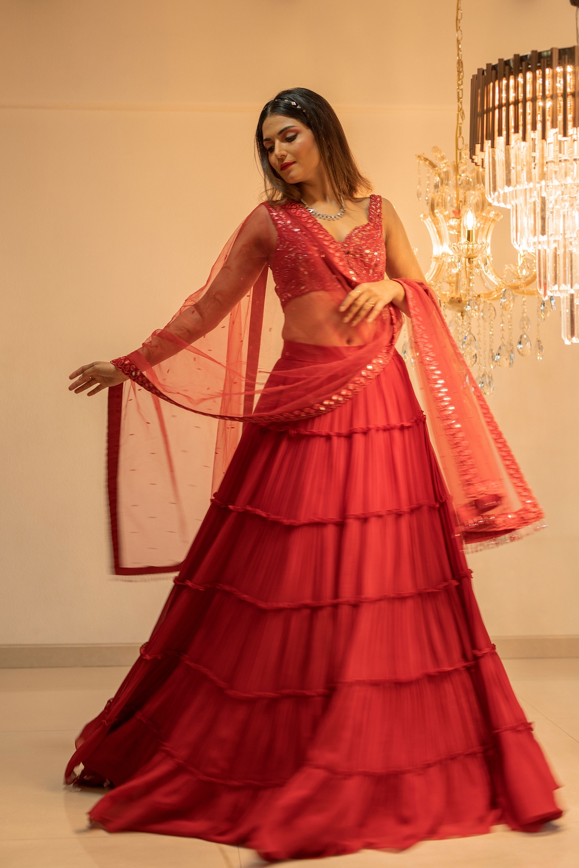 A model showcasing Red Tiered Mirror Work Lehenga Set Feature image by Foram Patel from Foram Patel's collection