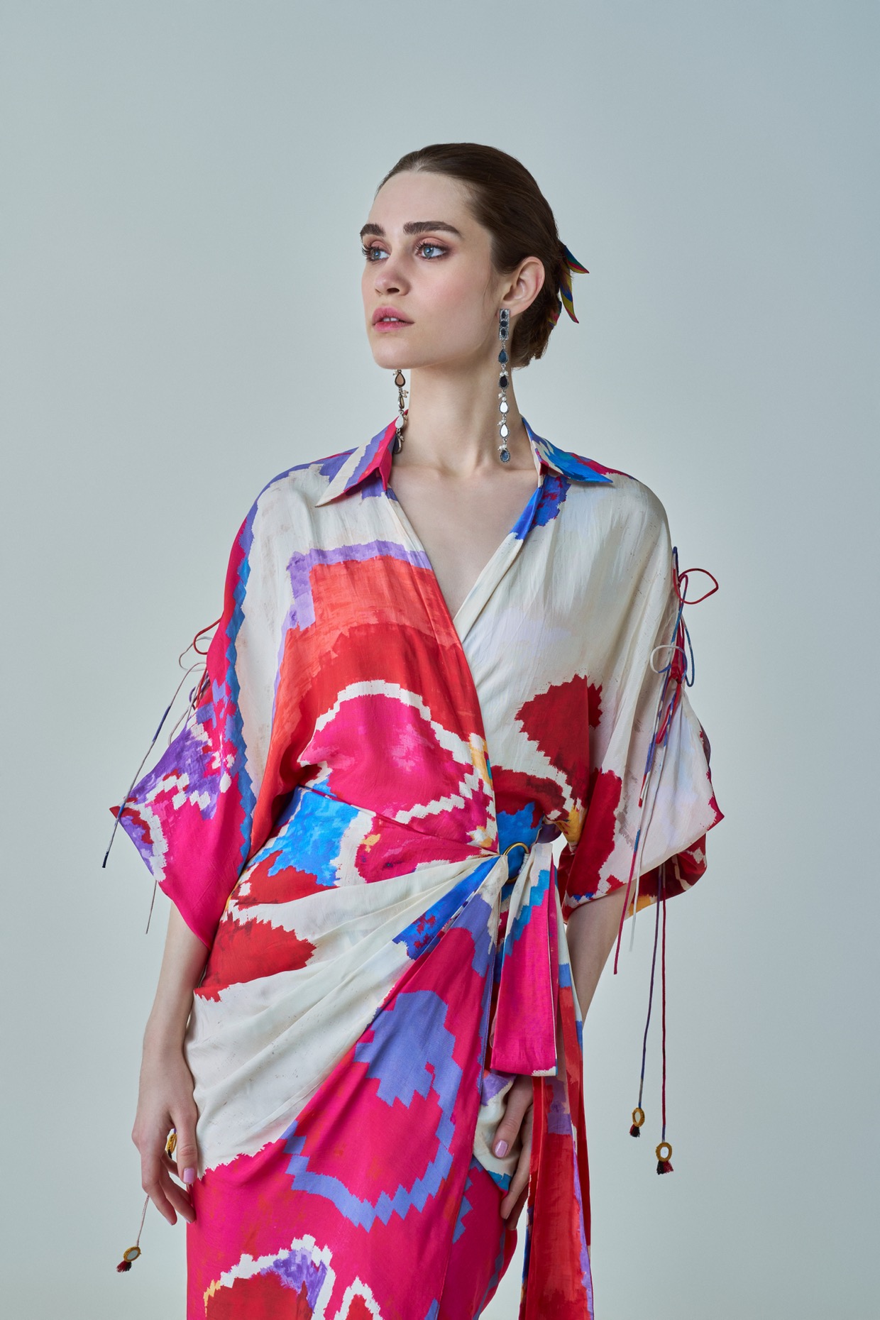 A model showcasing Evelyn Dress Pink Red Wrap Up Assymetric Dress by Saaksha And Kinni from Saaksha And Kinni's collection