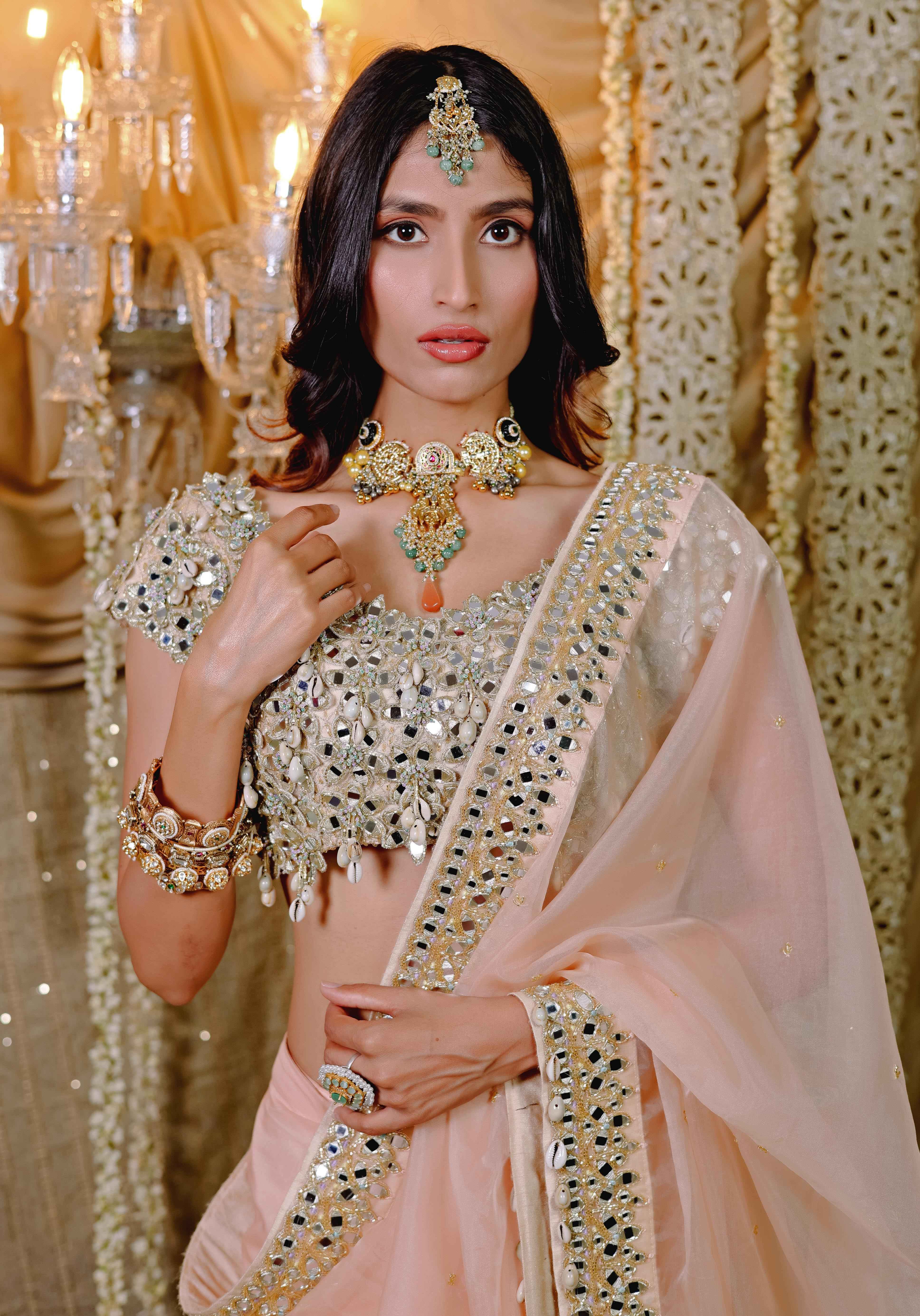 A model showcasing Peach Embroidered Predraped Saree Set by Foram Patel from Foram Patel's collection