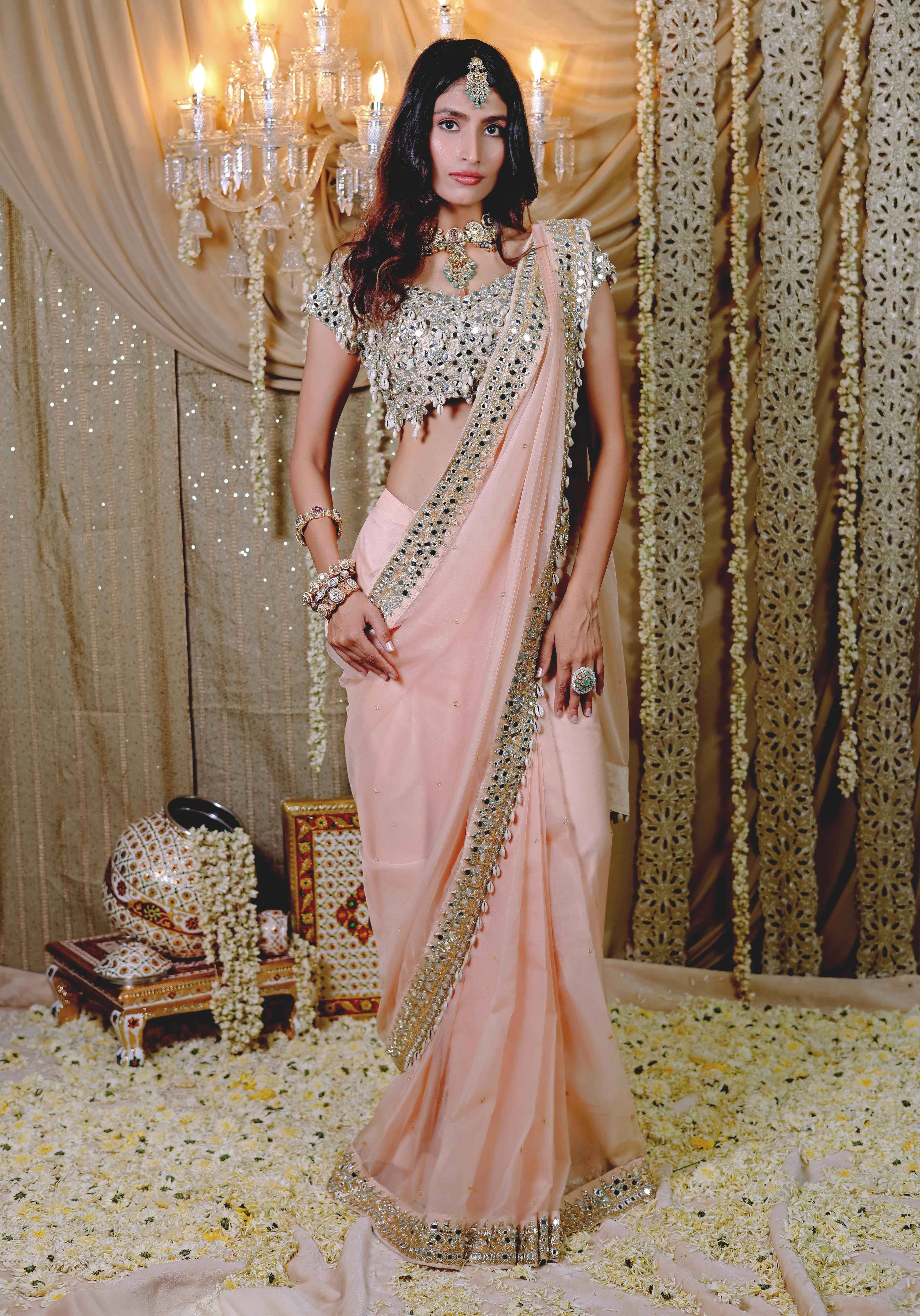 A model showcasing Peach Embroidered Predraped Saree Set by Foram Patel from Foram Patel's collection