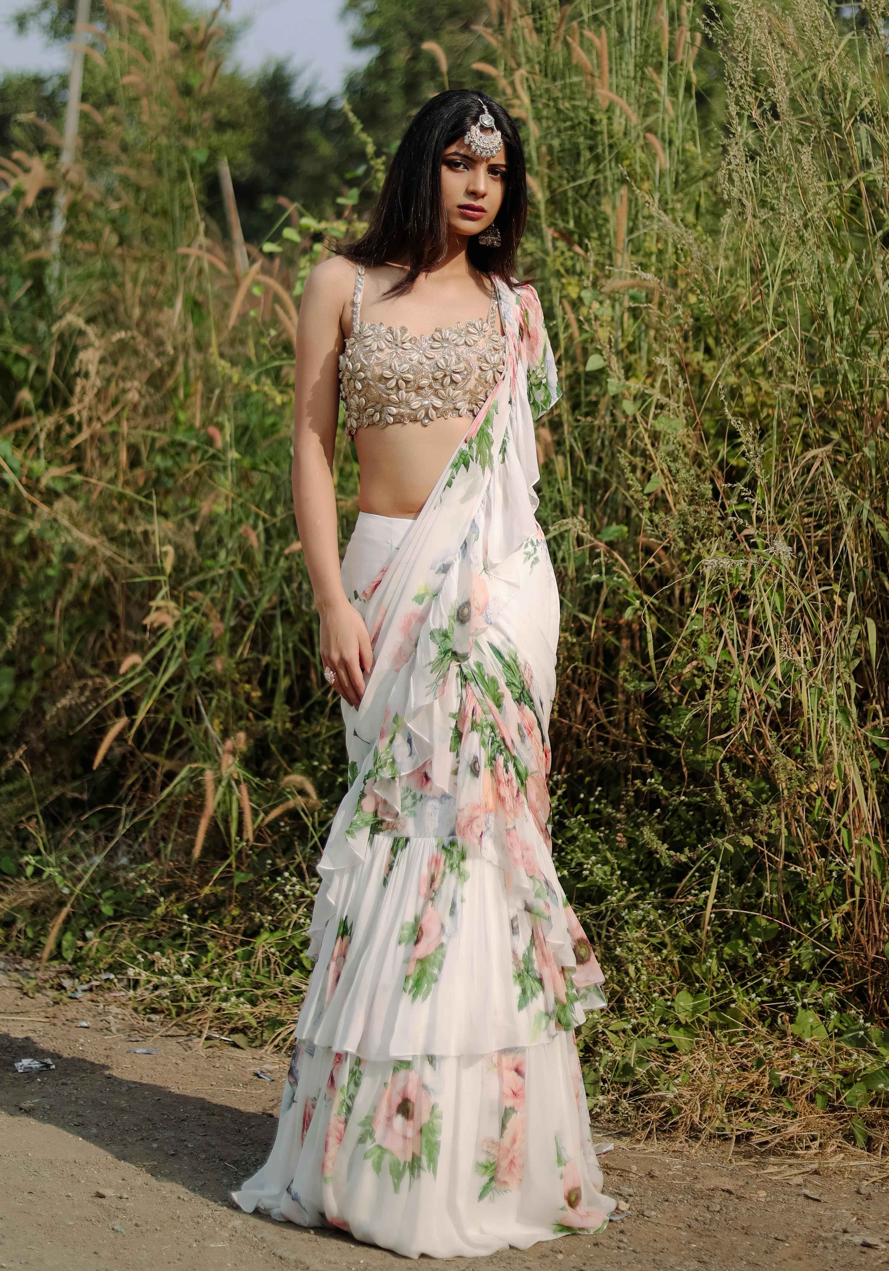 A model showcasing White Floral Printed Ruffle Predraped Saree Set by Foram Patel from Foram Patel's collection