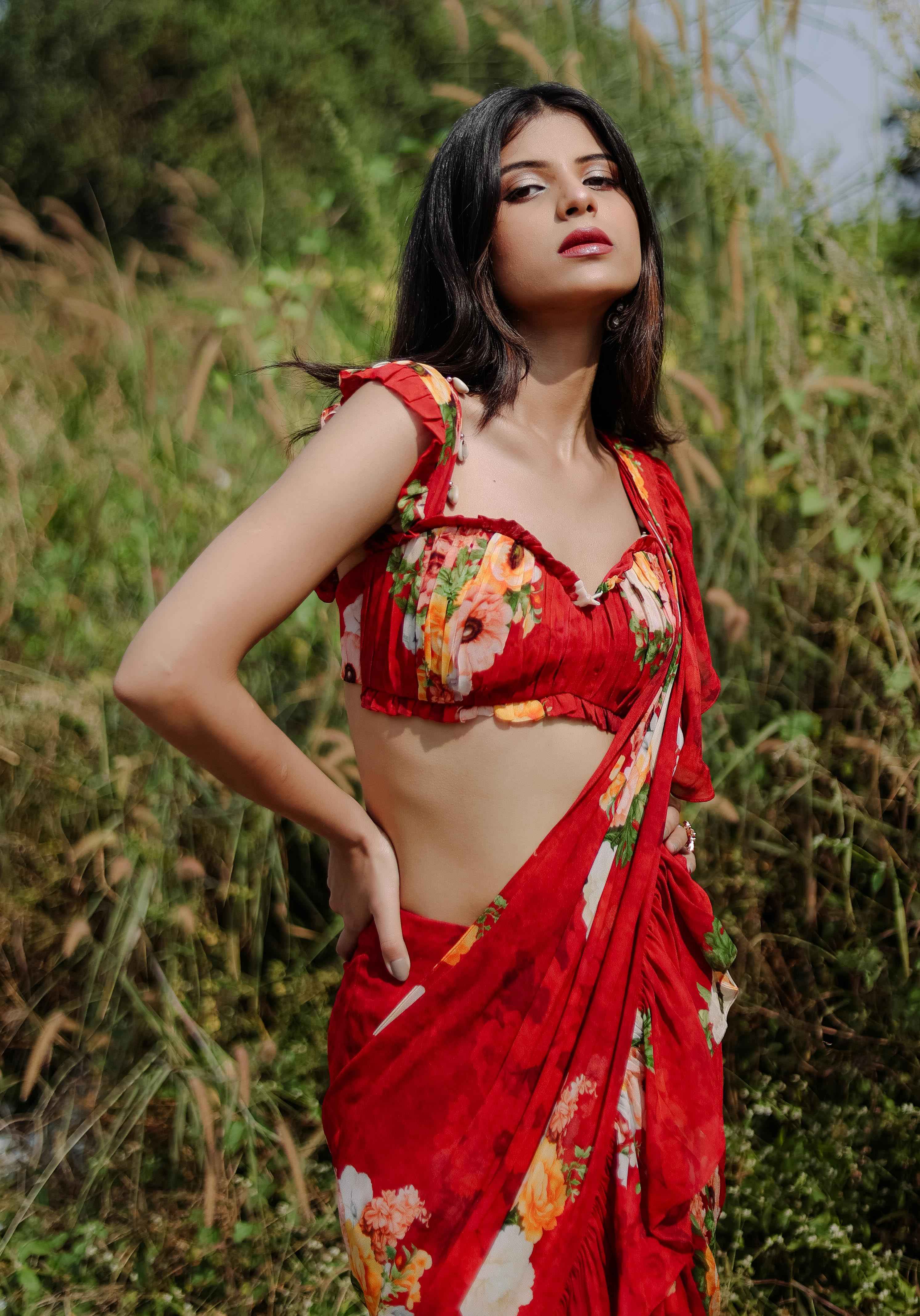 A model showcasing Red Floral Printed Predraped Ruffle Saree Set by Foram Patel from Foram Patel's collection