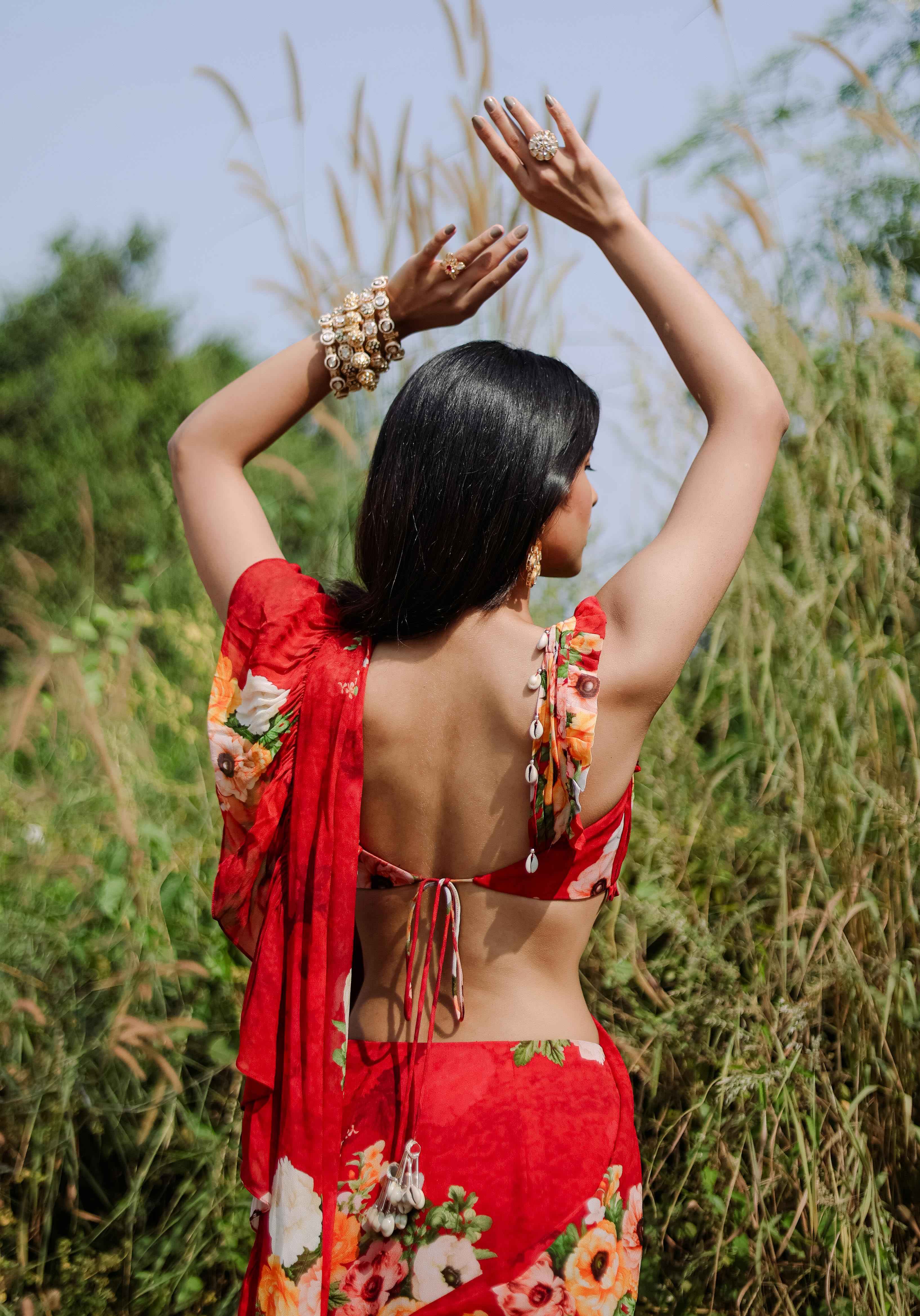 A model showcasing Red Floral Printed Predraped Ruffle Saree Set by Foram Patel from Foram Patel's collection