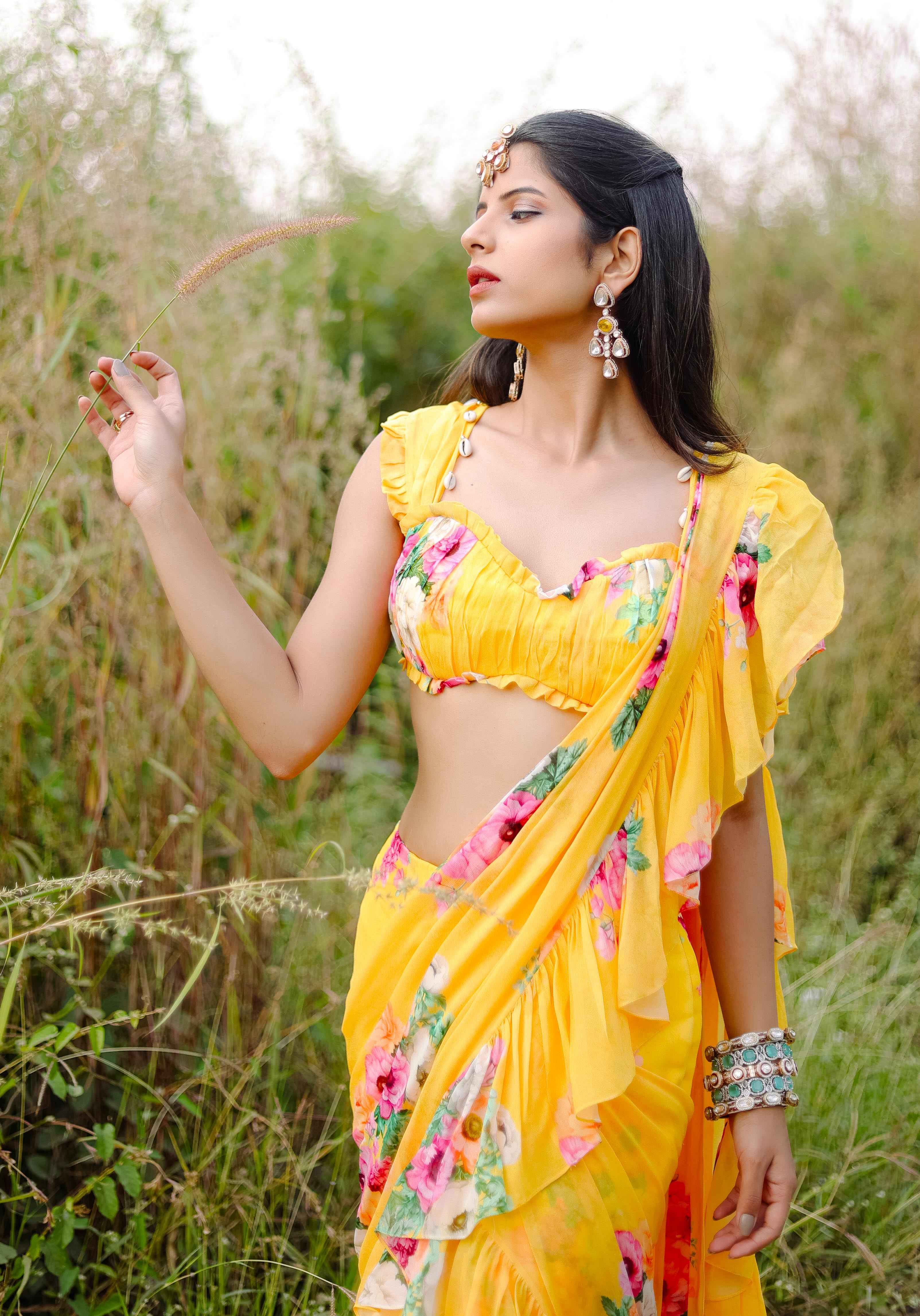 A model showcasing Yellow Floral Printed Predraped Ruffle Saree Set by Foram Patel from Foram Patel's collection