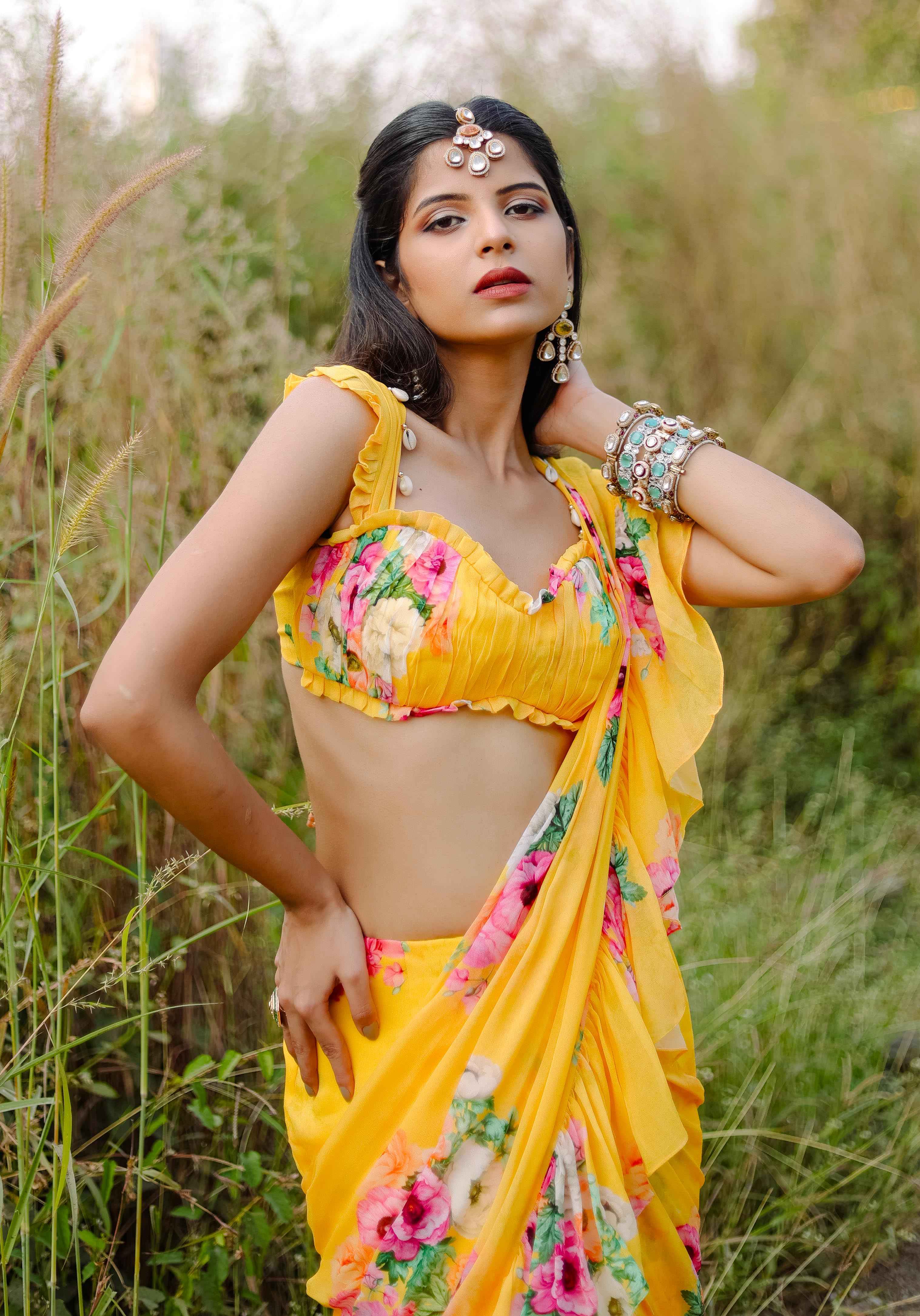 A model showcasing Yellow Floral Printed Predraped Ruffle Saree Set by Foram Patel from Foram Patel's collection