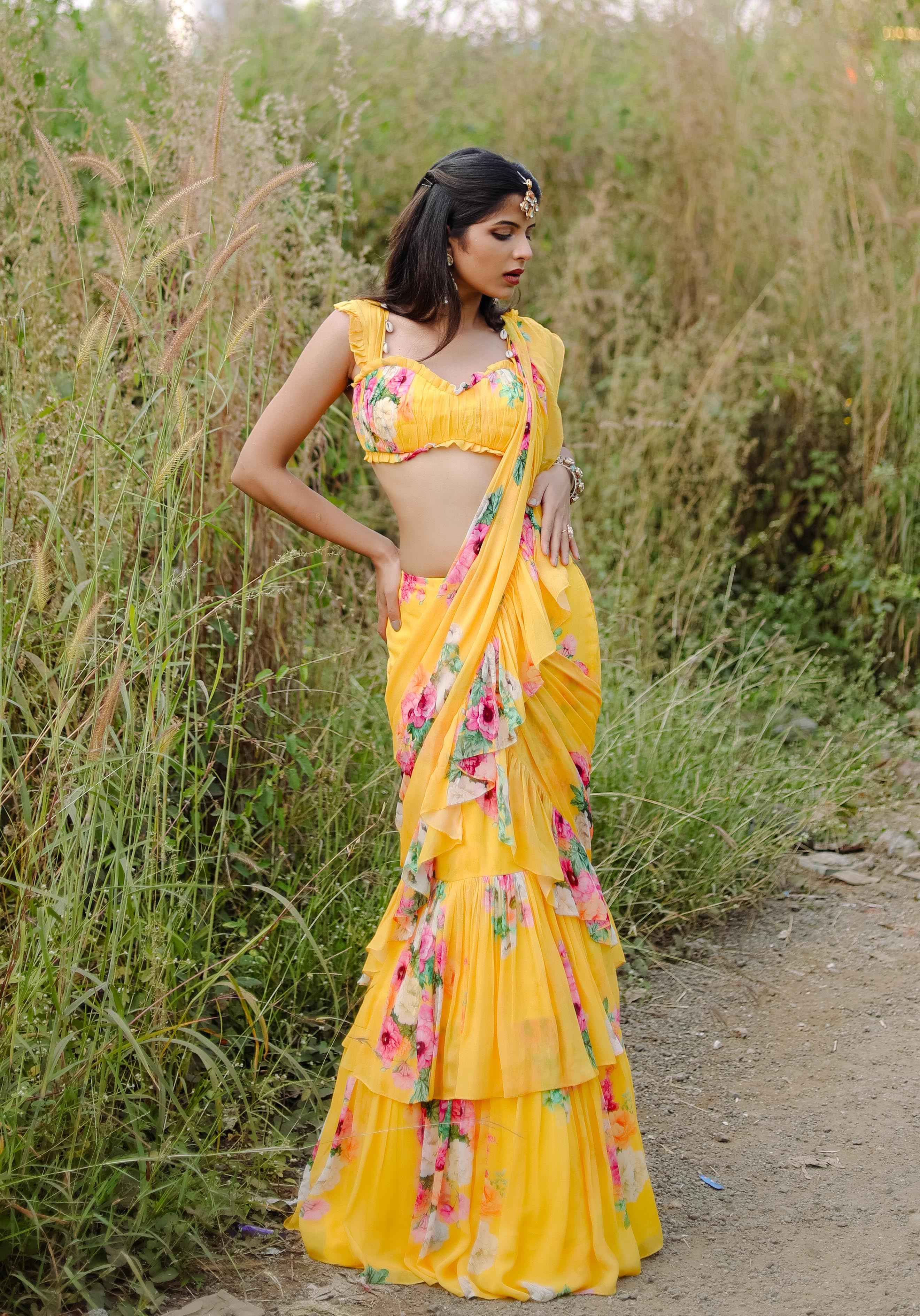 A model showcasing Yellow Floral Printed Predraped Ruffle Saree Set by Foram Patel from Foram Patel's collection