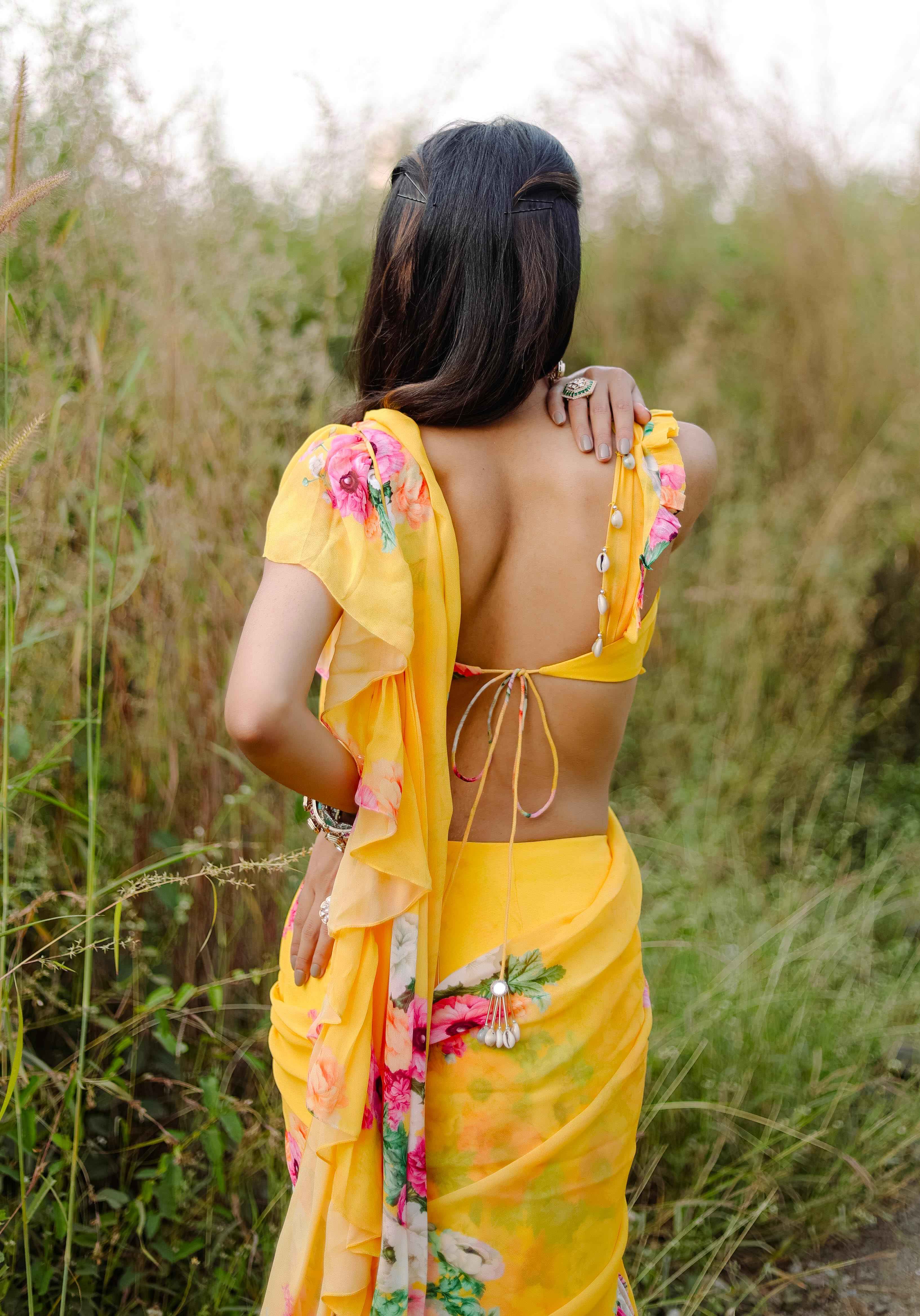 A model showcasing Yellow Floral Printed Predraped Ruffle Saree Set by Foram Patel from Foram Patel's collection