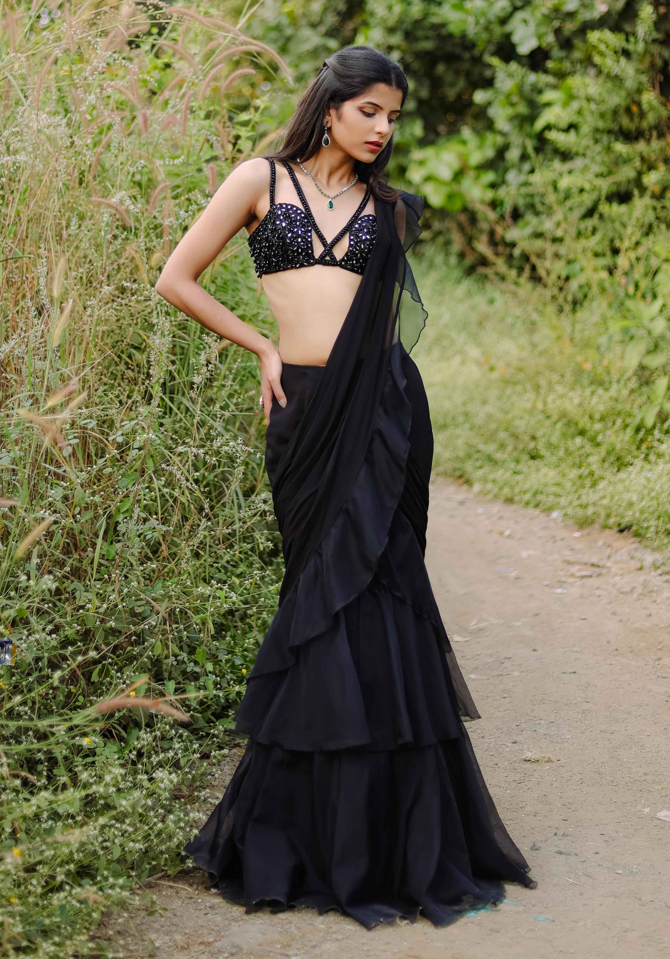 A model showcasing Black Embroidered Ruffle Predraped Saree Set by Foram Patel from Foram Patel's collection