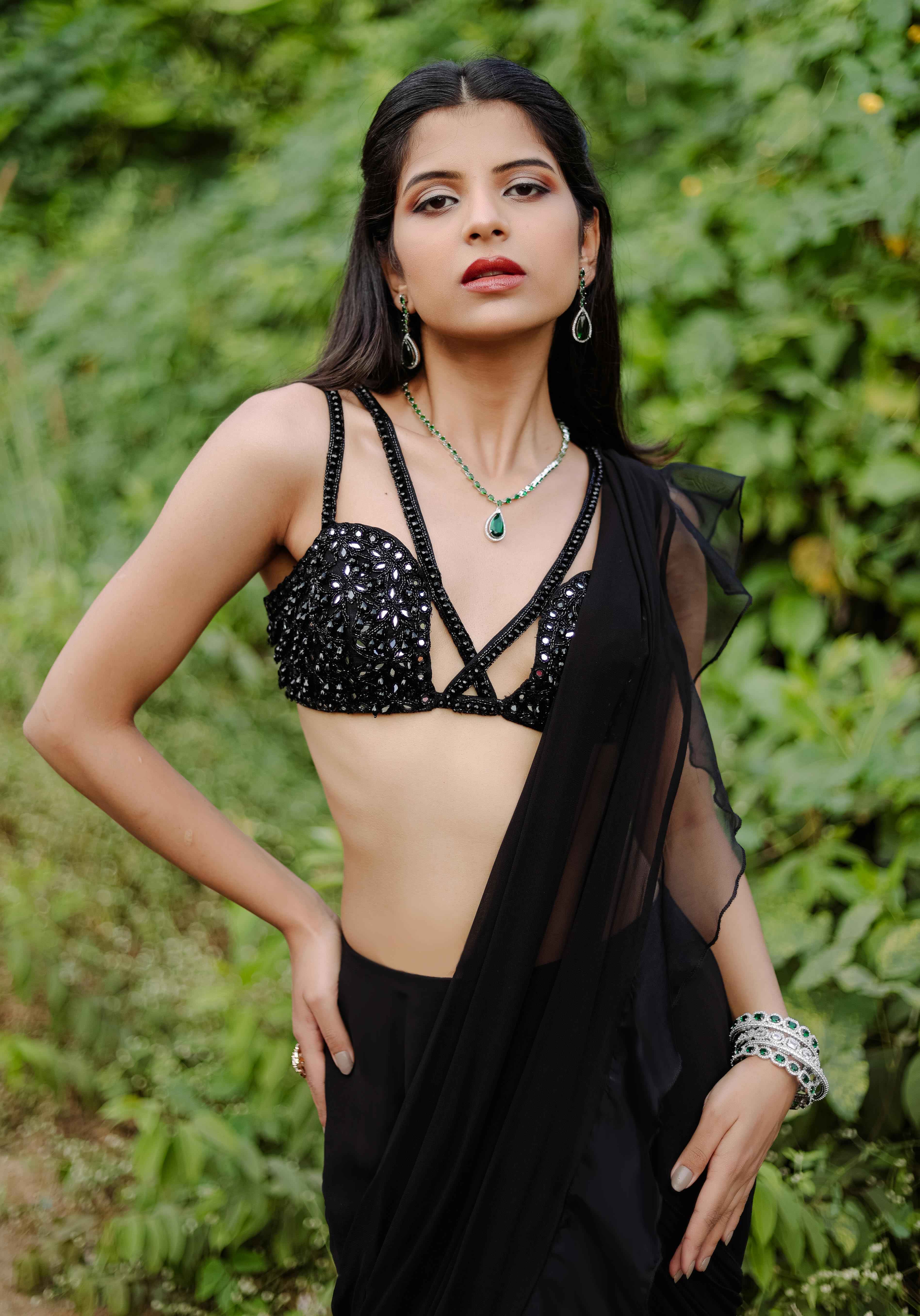 A model showcasing Black Embroidered Ruffle Predraped Saree Set by Foram Patel from Foram Patel's collection