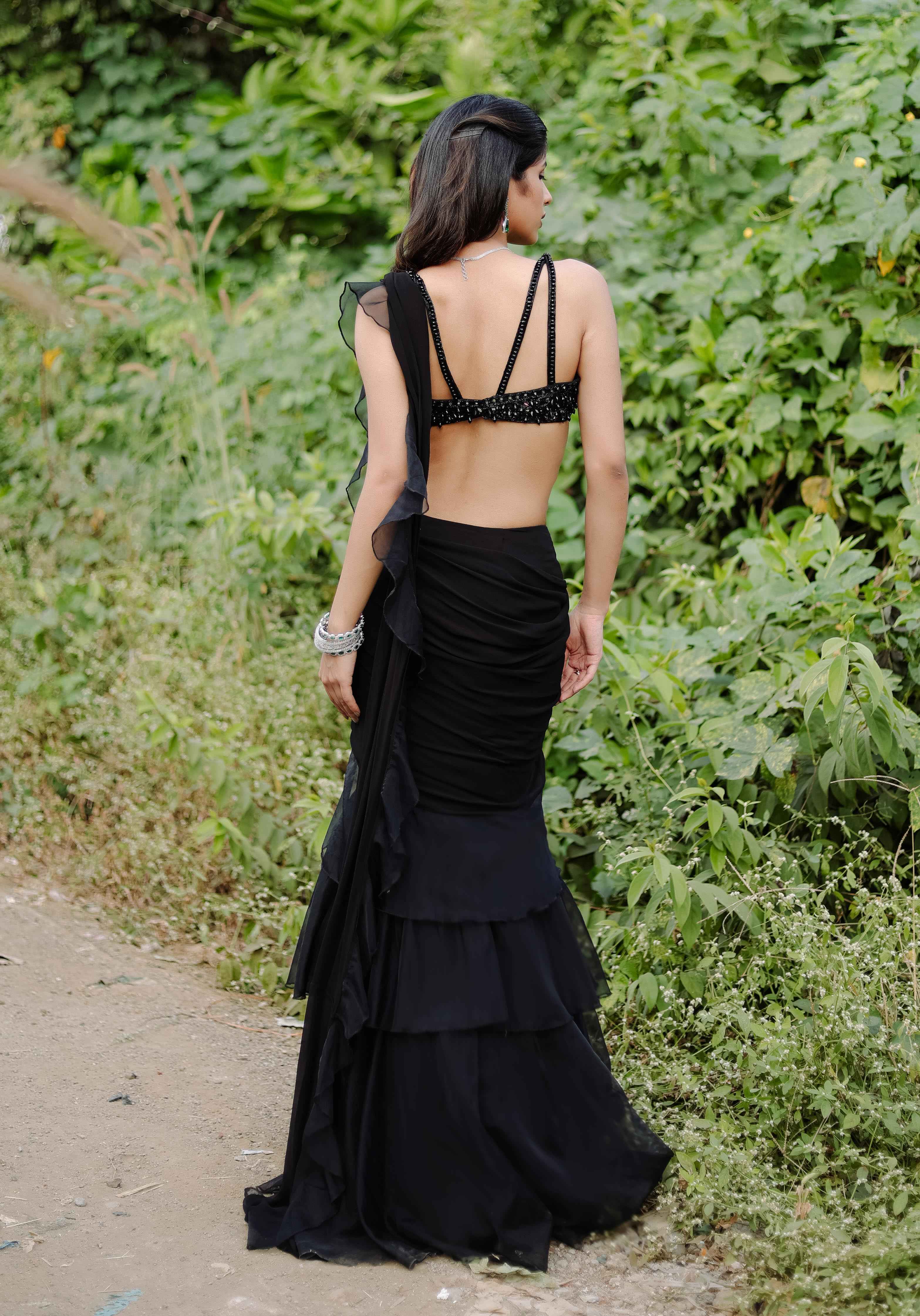 A model showcasing Black Embroidered Ruffle Predraped Saree Set by Foram Patel from Foram Patel's collection