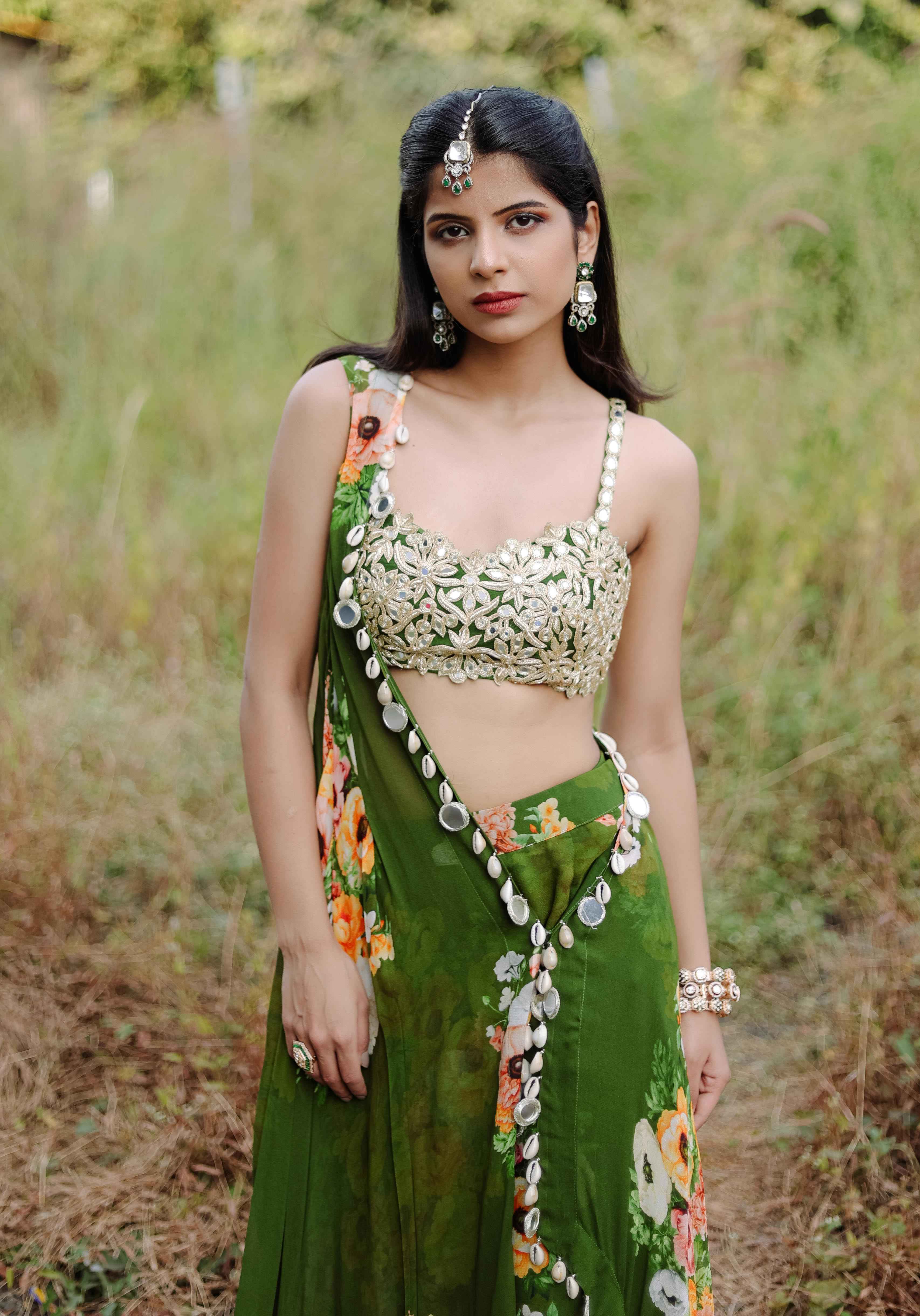 A model showcasing Green Mirror And Cowrie Embroidered Cape Set by Foram Patel from Foram Patel's collection