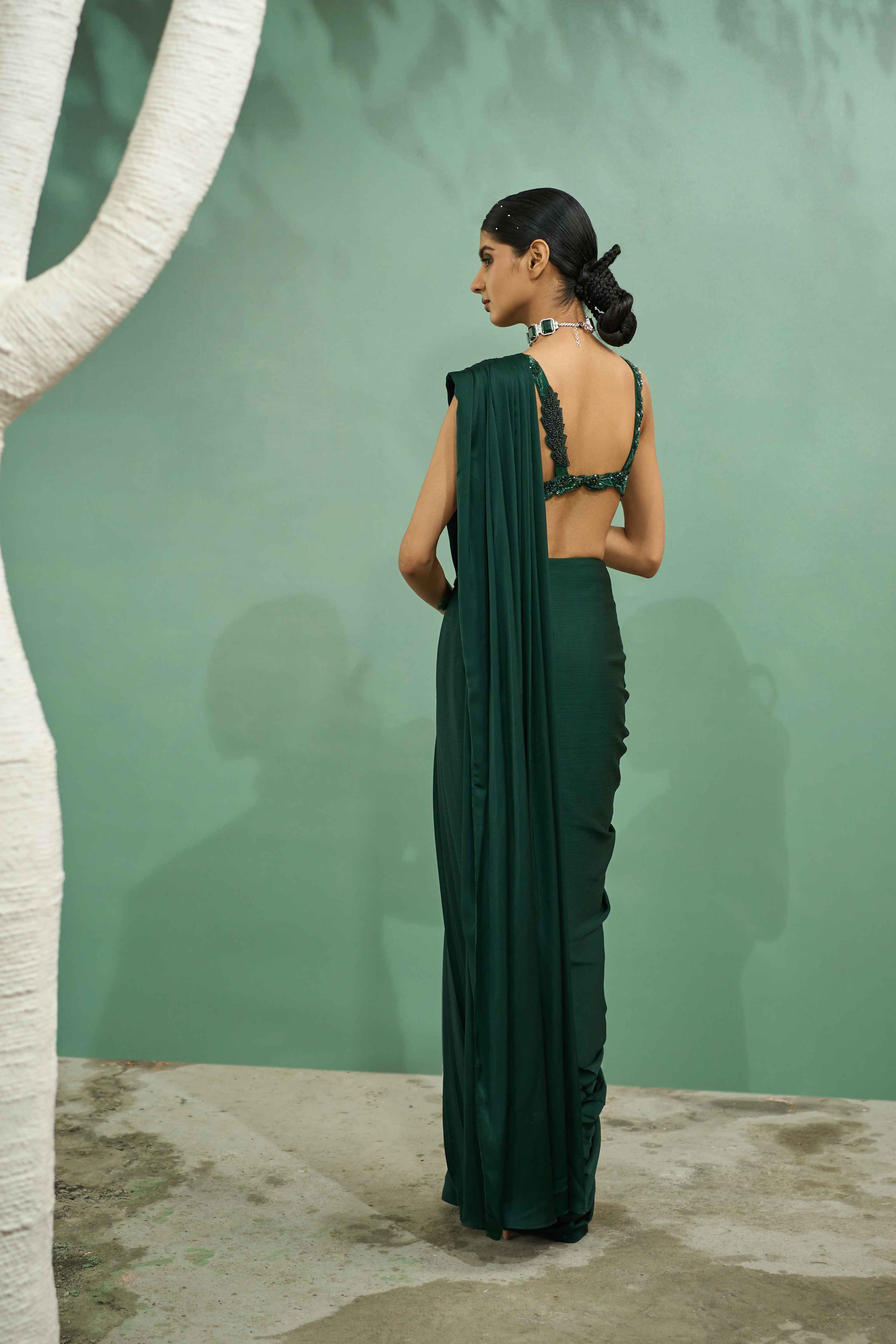 A model showcasing Emerald Green Cutwork Drape Saree Set by One Knot One from One Knot One's collection A model showcasing Emerald Green Cutwork Drape Saree Set by One Knot One from One Knot One's collection