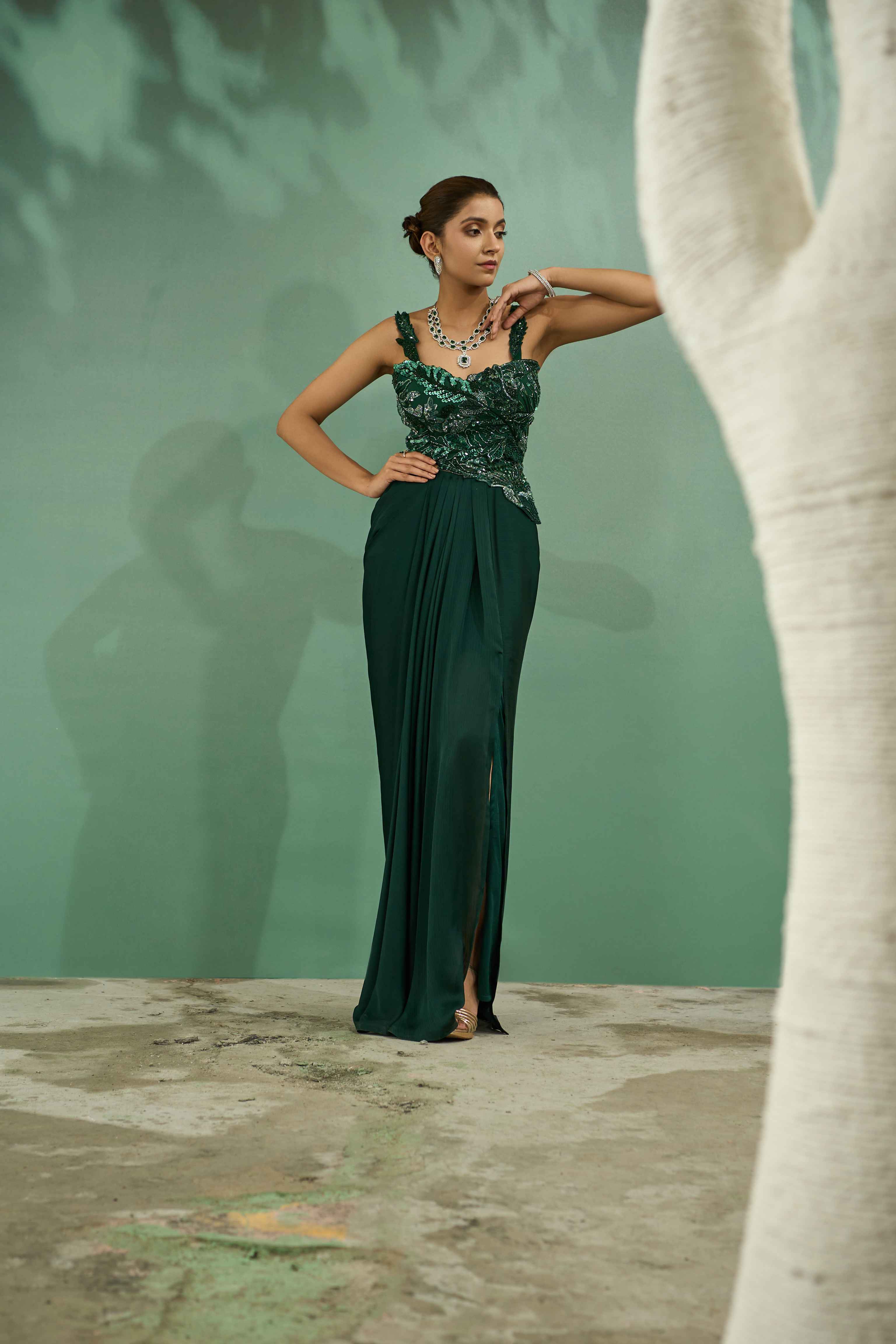 A model showcasing Emerald Green Cutwork Top And Drape Skirt Set by One Knot One from One Knot One's collection